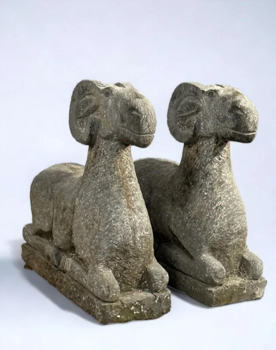 Pair of carved stone ram garden figures, hand-finished with a chiseled look. Poised in a recumbent position, 20th century production. 