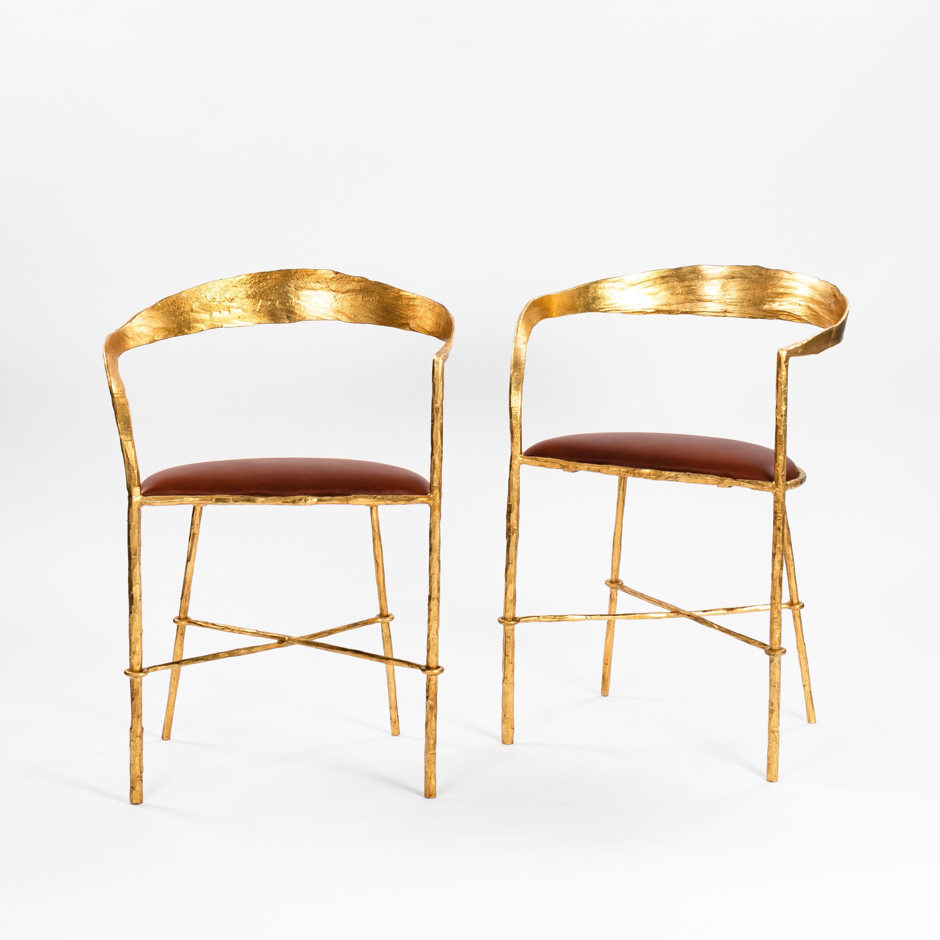 Paar handgeschmiedete vergoldete Stühle aus der Mitte des Jahrhunderts von Banci Florenz 1970er Jahre

Die Stühle sind von zarter Struktur, aber sehr schwer.
Eine Armlehne ist gebogen, die andere geht gerade in die Rückenlehne über. 
Der Rahmen ist
