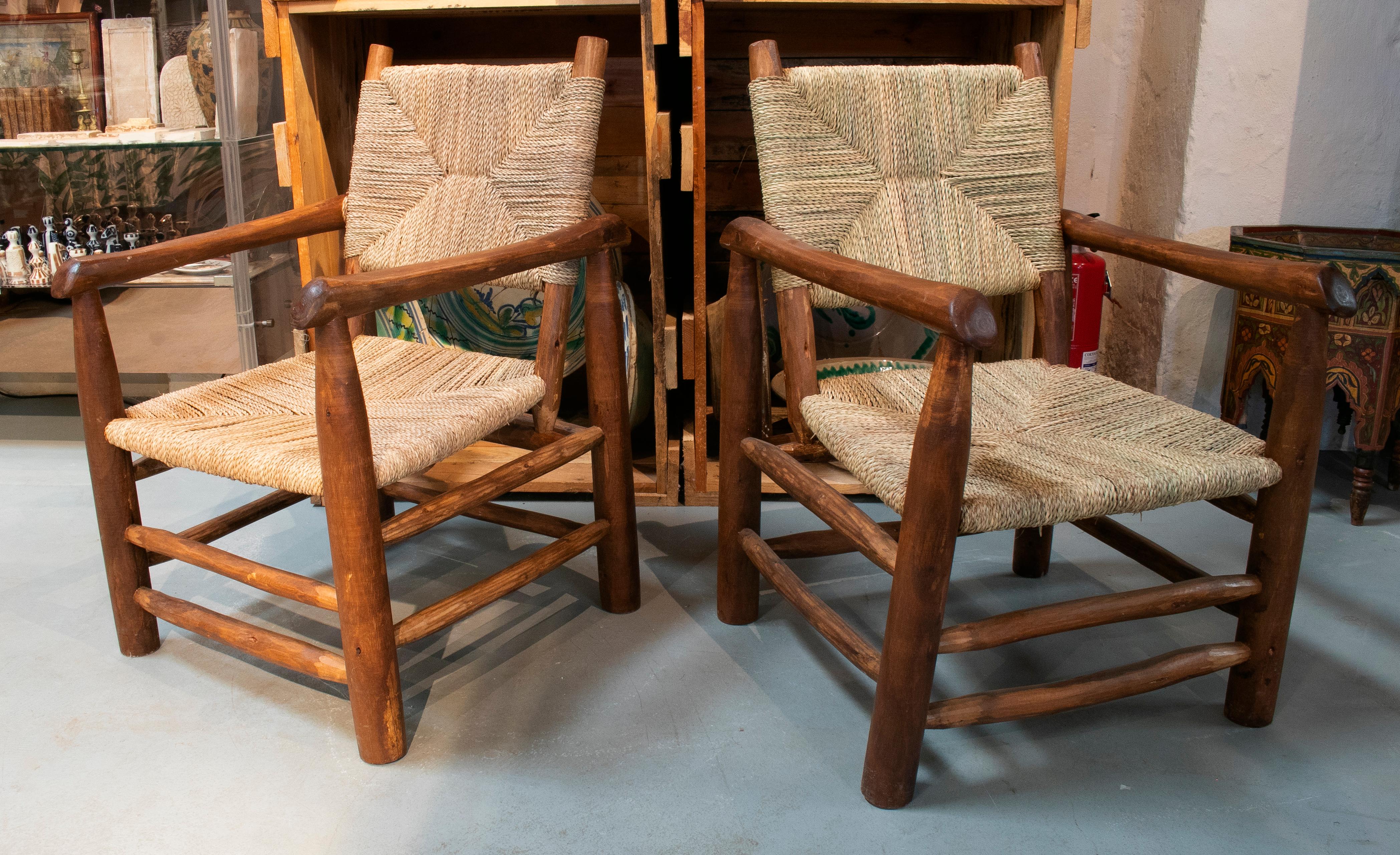 Pair of handmade light brown wooden armchairs with string rope back and seat.