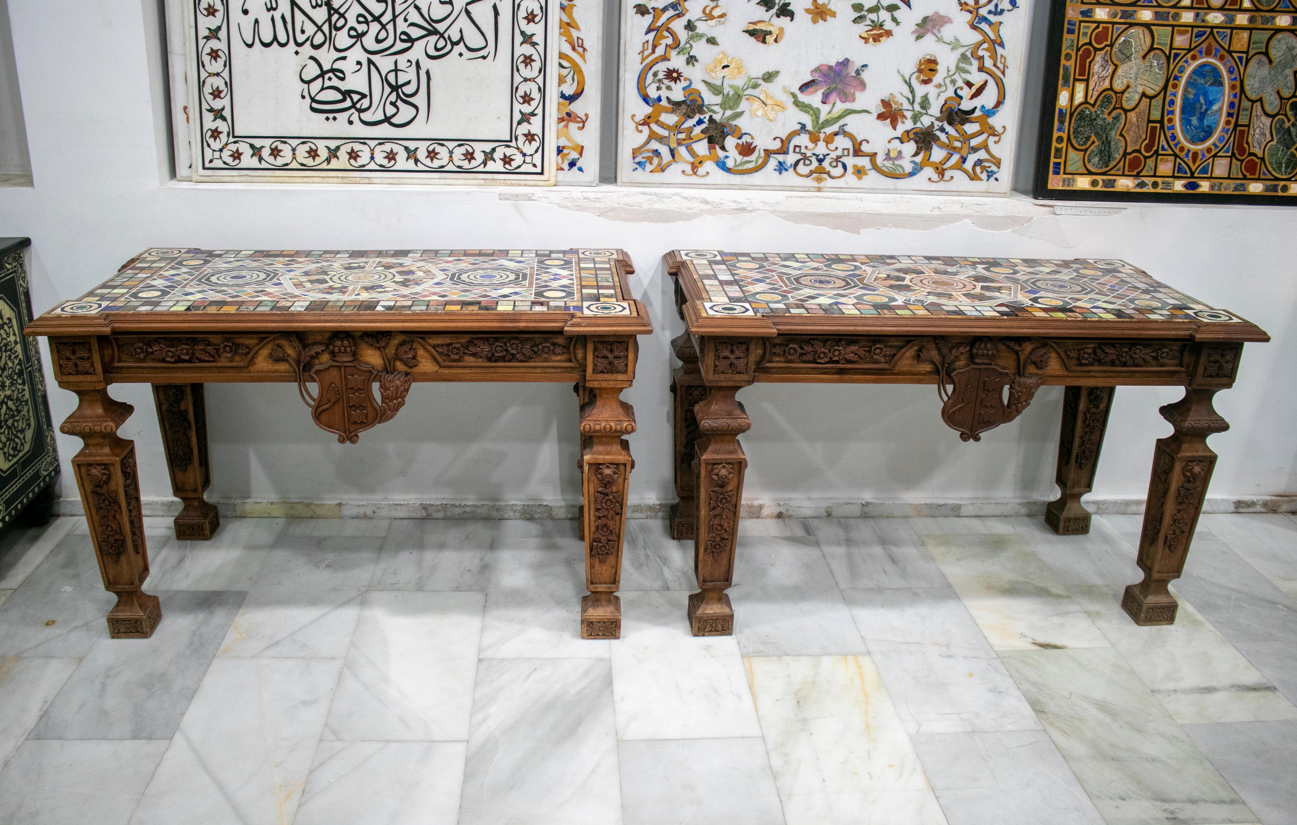 Pareja de mosaicos rectangulares de pietre dure hechos a mano con lapislázuli azul, jaspe oceánico, amatista azul y otras piedras semipreciosas.

Ambas encimeras están colocadas en mesas de madera tallada a mano en relieve, con crestas y motivos