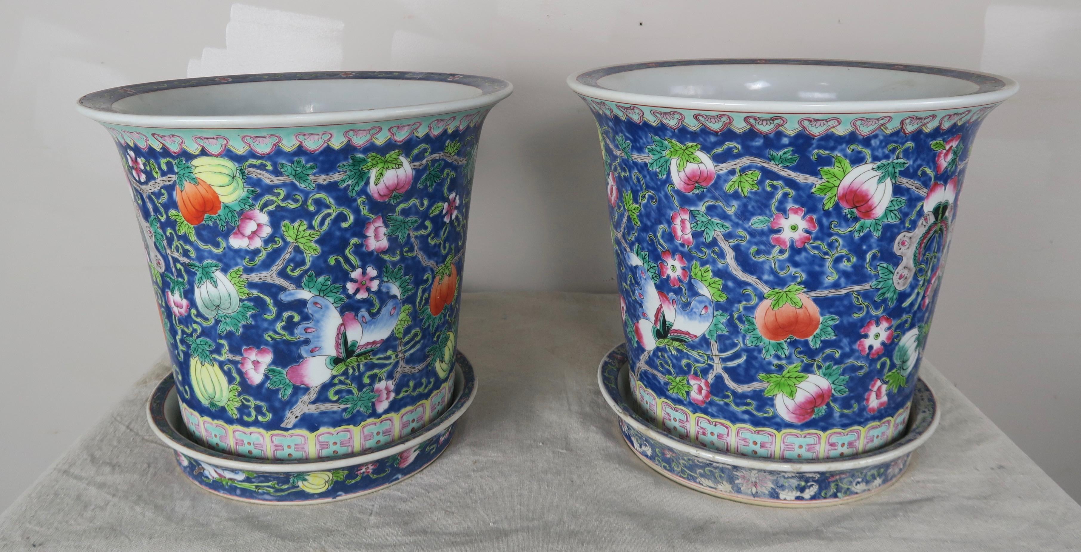 Pair of beautifully painted glazed ceramic pots in shades of blue, green and tangerine. The pots include saucers. Notice the beautiful images painted including pumpkins, flowers, butterflies and so much more.