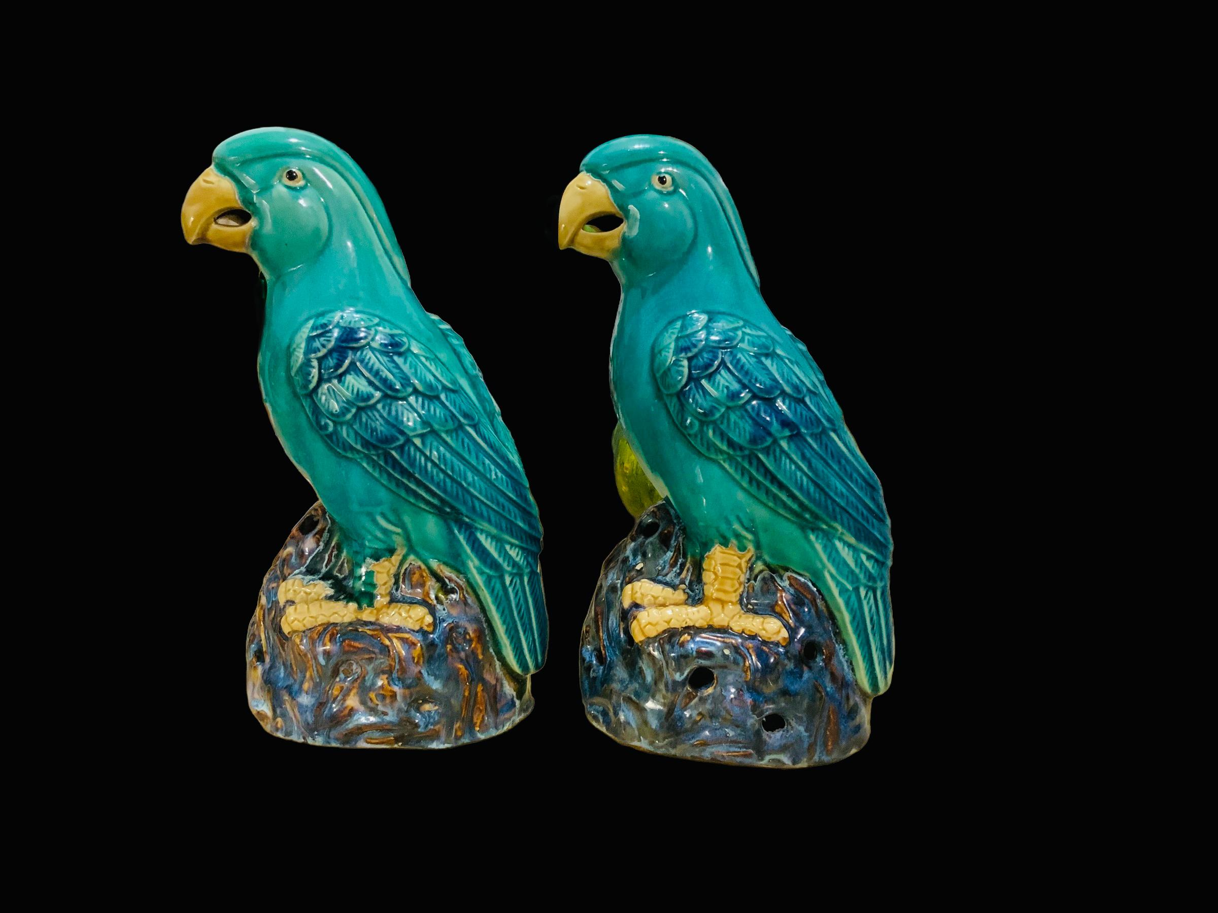 This is a pair of Chinese hand painted ceramic parrots. They catch your eyes wherever you display them. They are large and heavy. The light turquoise color of their bodies with royal blue details in their feathers enhance their yellow peaks and