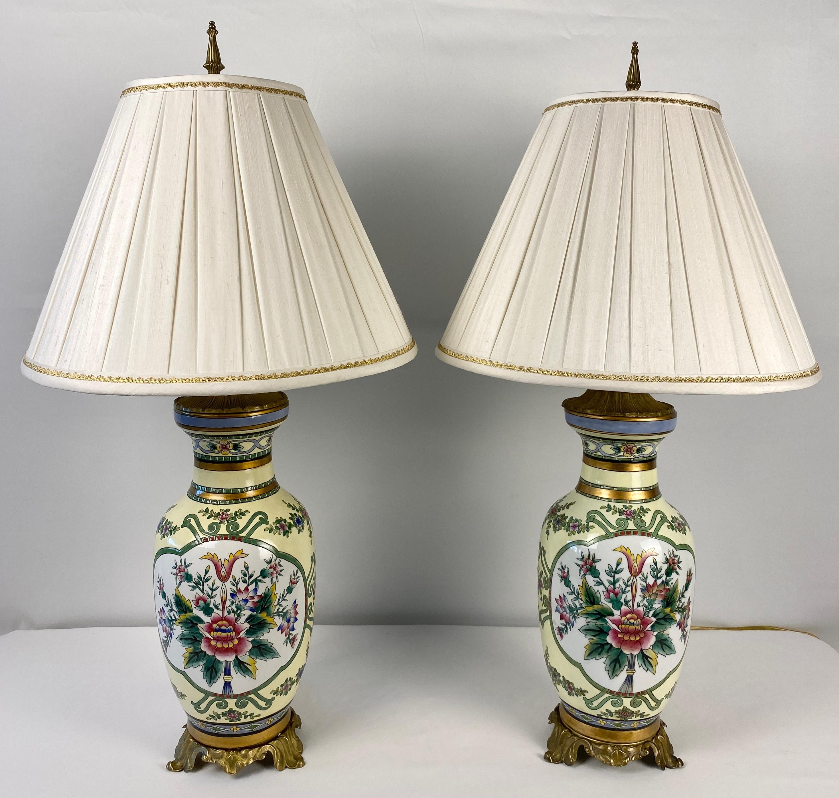 Pair of beautiful, French hand-painted porcelain table lamps with floral decor each mounted on a gilt bronze base. 

Adorned with a rich painted finish in the white, yellow, green and rose palette. Place this pair of French hand-painted porcelain