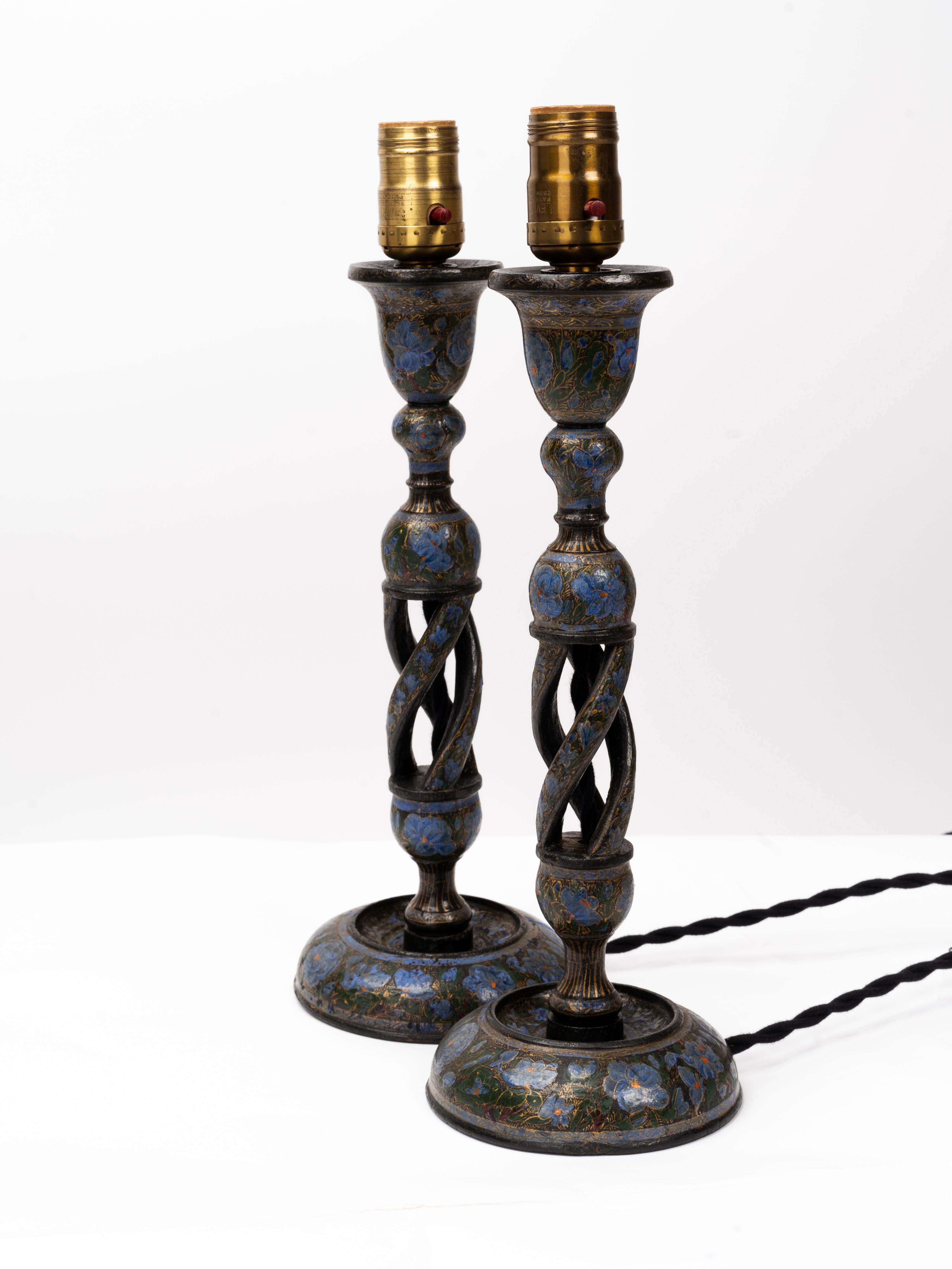 Elegant pair of carefully handcrafted, candlesticks from Northern India, converted into table lamps. Delicately hand painted with lacquer on a turned coirwood base.

The candlesticks were at some point retrofitted into table lamps. We rewired the