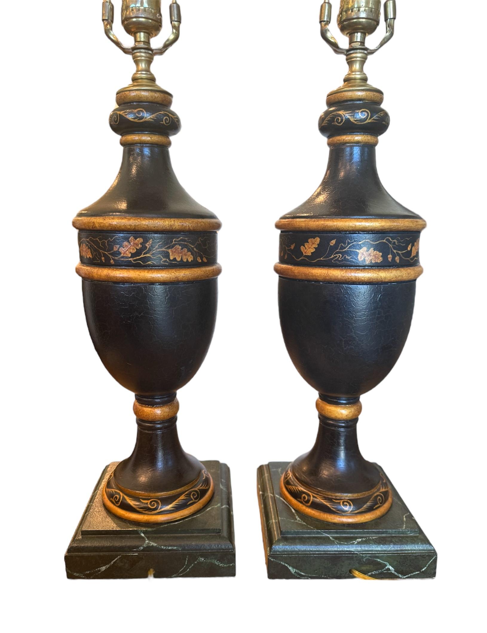 Entdecken Sie eine einzigartige Mischung aus skurrilem Charme und opulentem Design mit diesem exquisiten, handbemalten Lampenpaar mit entzückenden Mops-Porträts. Jeder Lampensockel, der die Form einer eleganten Urne hat, ist sorgfältig schwarz
