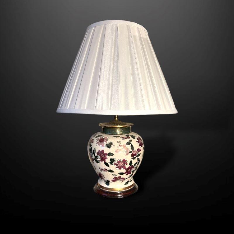 Paire de lampes de table orientales peintes à la main dans de riches tons rouges et roses. Le fond émaillé crème craquelé met en valeur le magnifique motif floral.

Chaque lampe est de forme balustre avec une bande dorée à la base, montée sur un