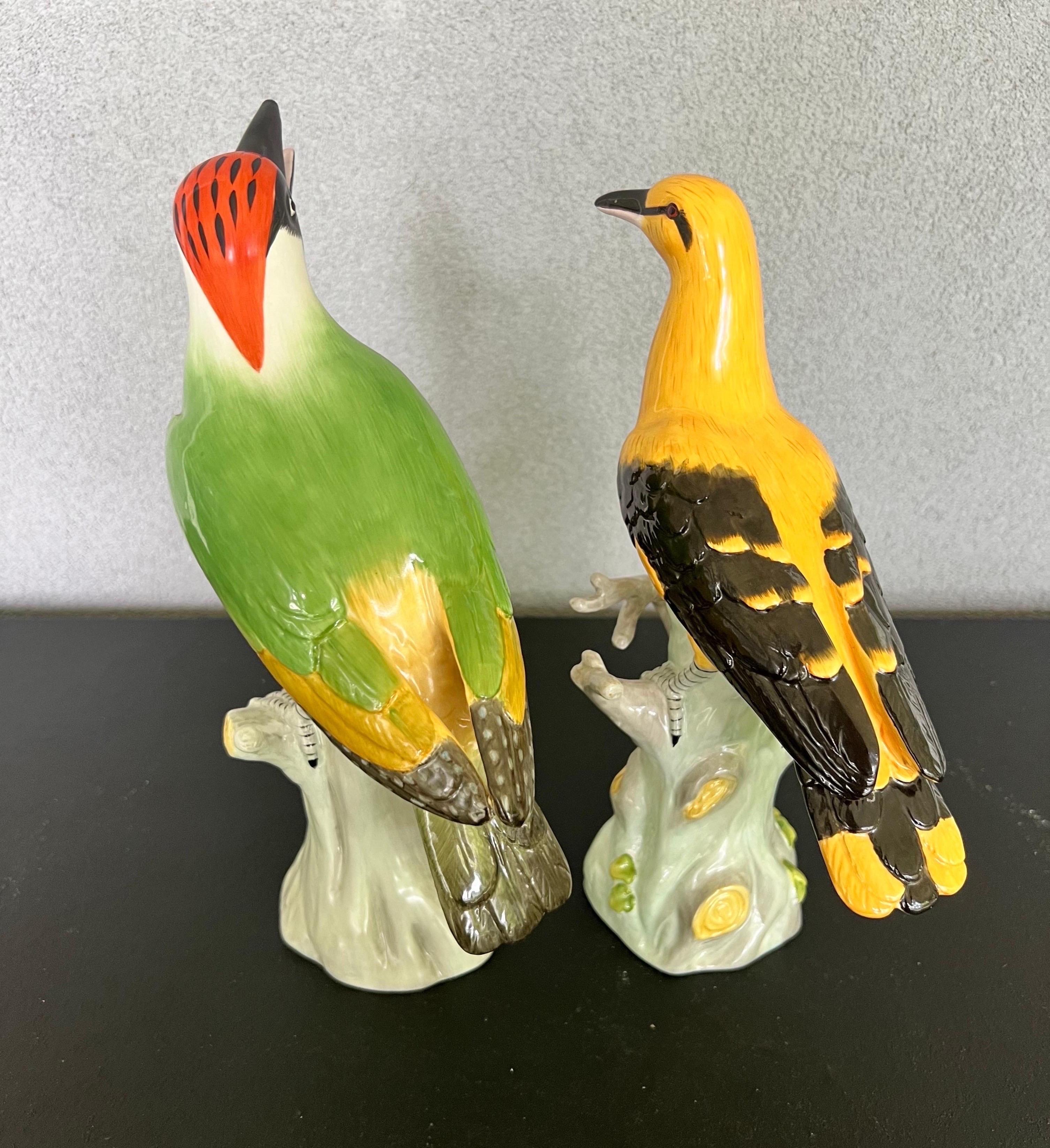 Gorgeous pair of porcelain hand-painted birds standing on a branch 
Made by Jeanne Reed’s for the Historic Charleston Foundation 
This pair would look stunning on a fireplace mantle ! colors are rich and details are beautiful 
Made in China 