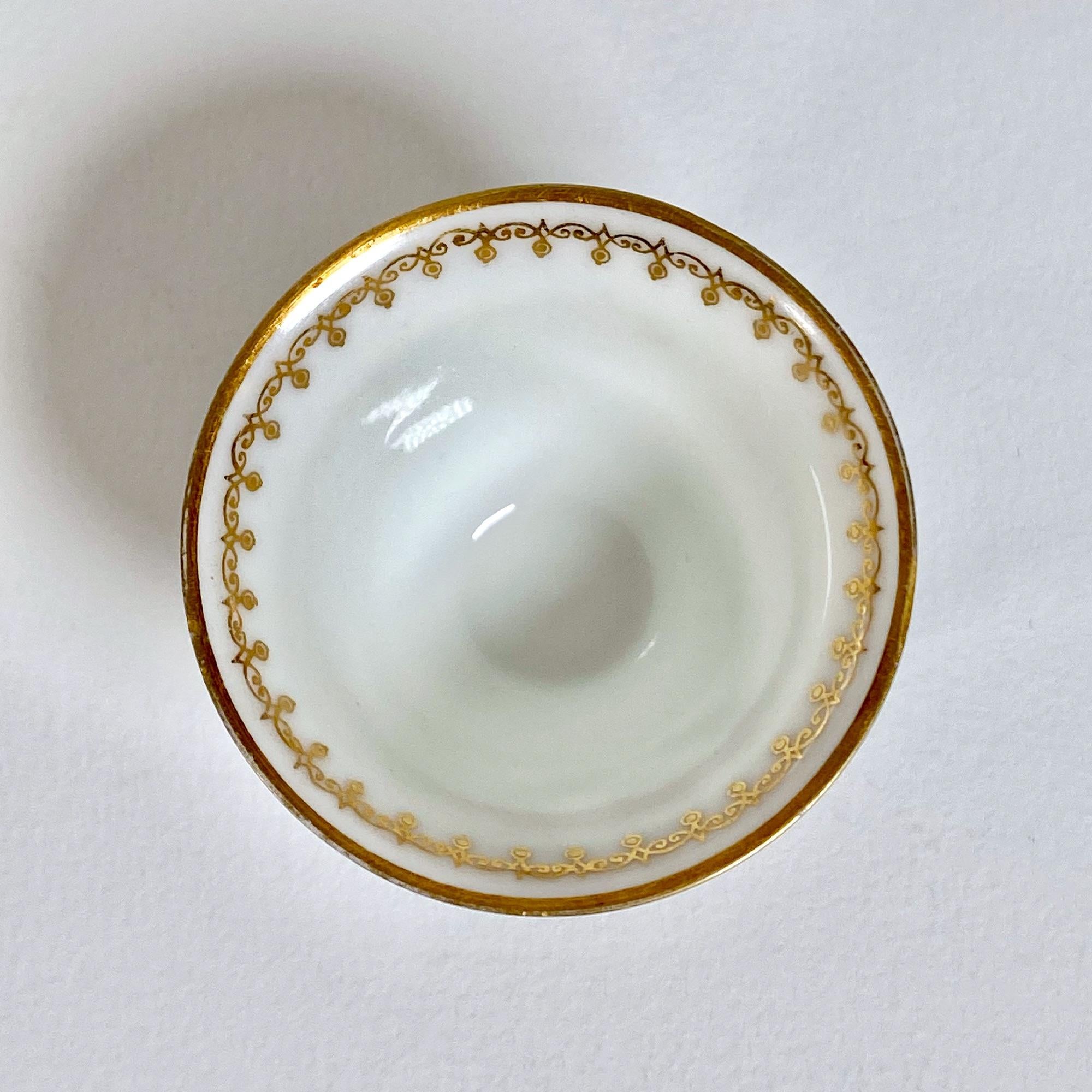Este exquisito par de tazas de porcelana pintadas a mano en la década de 1960 muestra una fina artesanía y una elegancia atemporal. Cada taza, de 4 cm de altura y 5,5 cm de diámetro, está adornada con un delicado diseño en pan de oro de 22 quilates
