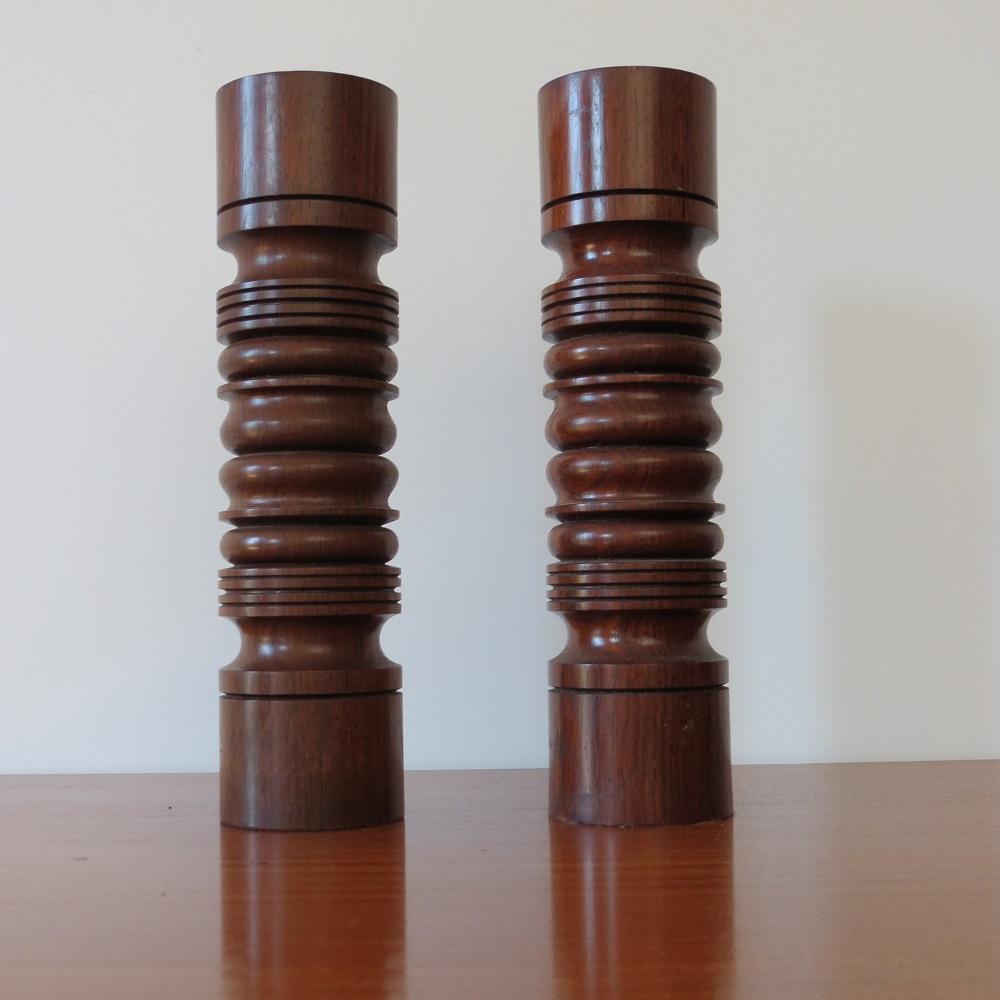 A pair of exceptional quality candle holders from the 1960s. Made from solid Padouk, with metal candle holder inserts and baize to the underside of each holder. Very well produced. In excellent condition. 
ST1376.