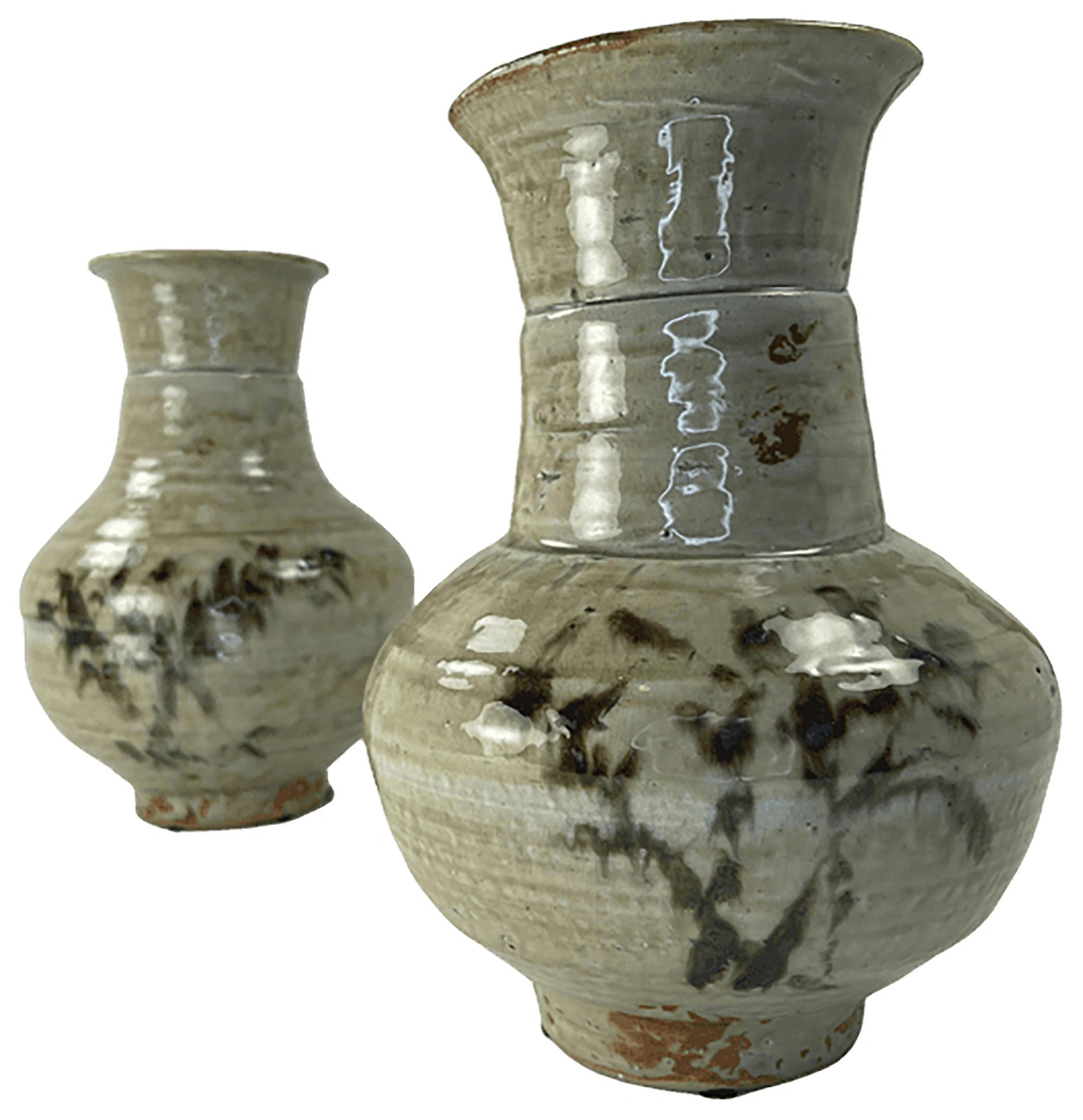 A handsome pair of hand turned, painted, and glazed clay vases. Possibly Korean in Origin. The finish is of a slightly greenish hand applied glaze. Painted bamboo or abstract trees adorn the sides of the vases. Hand turned and decorated. No visible