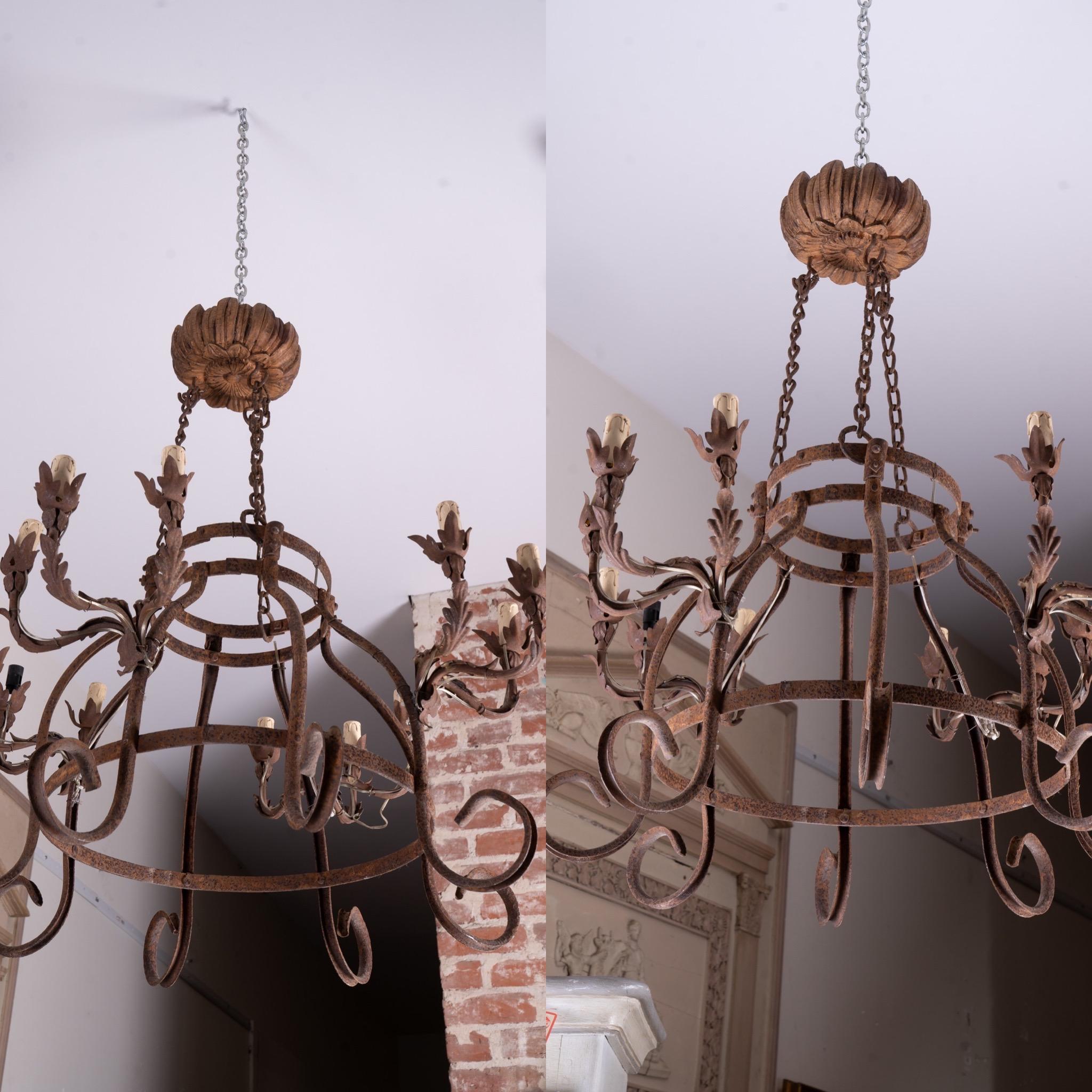 This pair of hand wrought highly decorative iron chandeliers would be perfect over a kitchen island or any covered outdoor space. Many customers have used iron chandeliers as pot holders in the kitchen or candle lighting in the garden. Having a pair