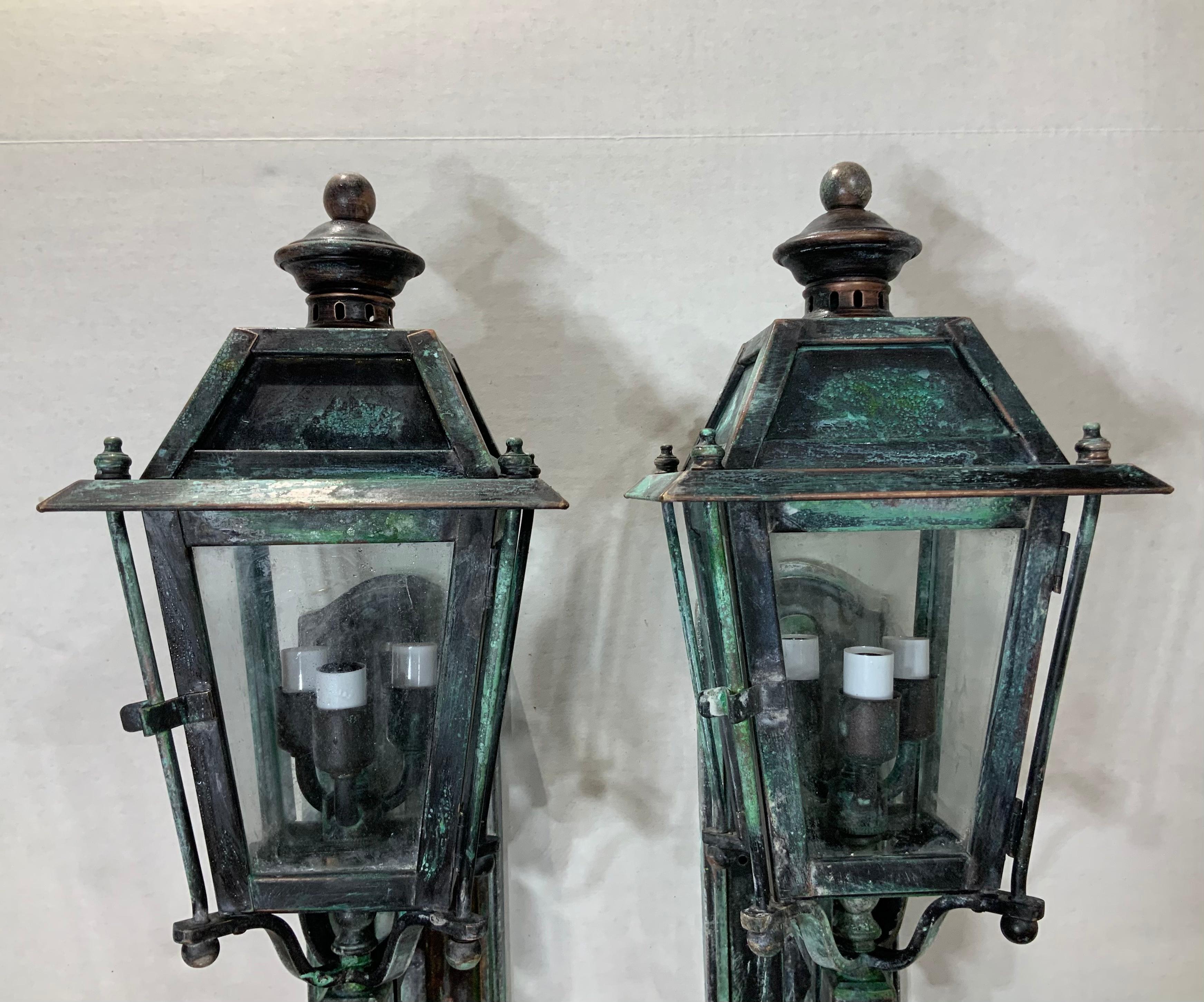 Pair of decorative lanterns, handcrafted from solid brass, electrified with 3 40/watt light each, UL approved, up to US code, suitable for wet locations. Very impressive pair for the front of the house. Some light green oxidization patina.