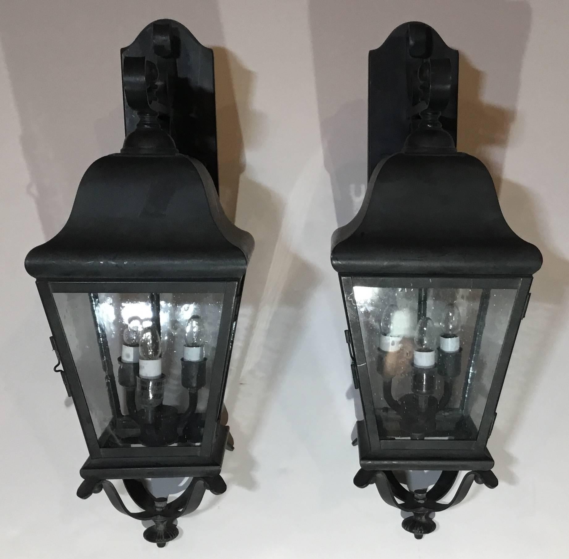 Impressive pair of lanterns handcrafted from solid brass, electrified with cluster of 3 40/watt lights each ready to hang in any great entrance . Seeded glass,UL approved up to US code suitable for wet locations.