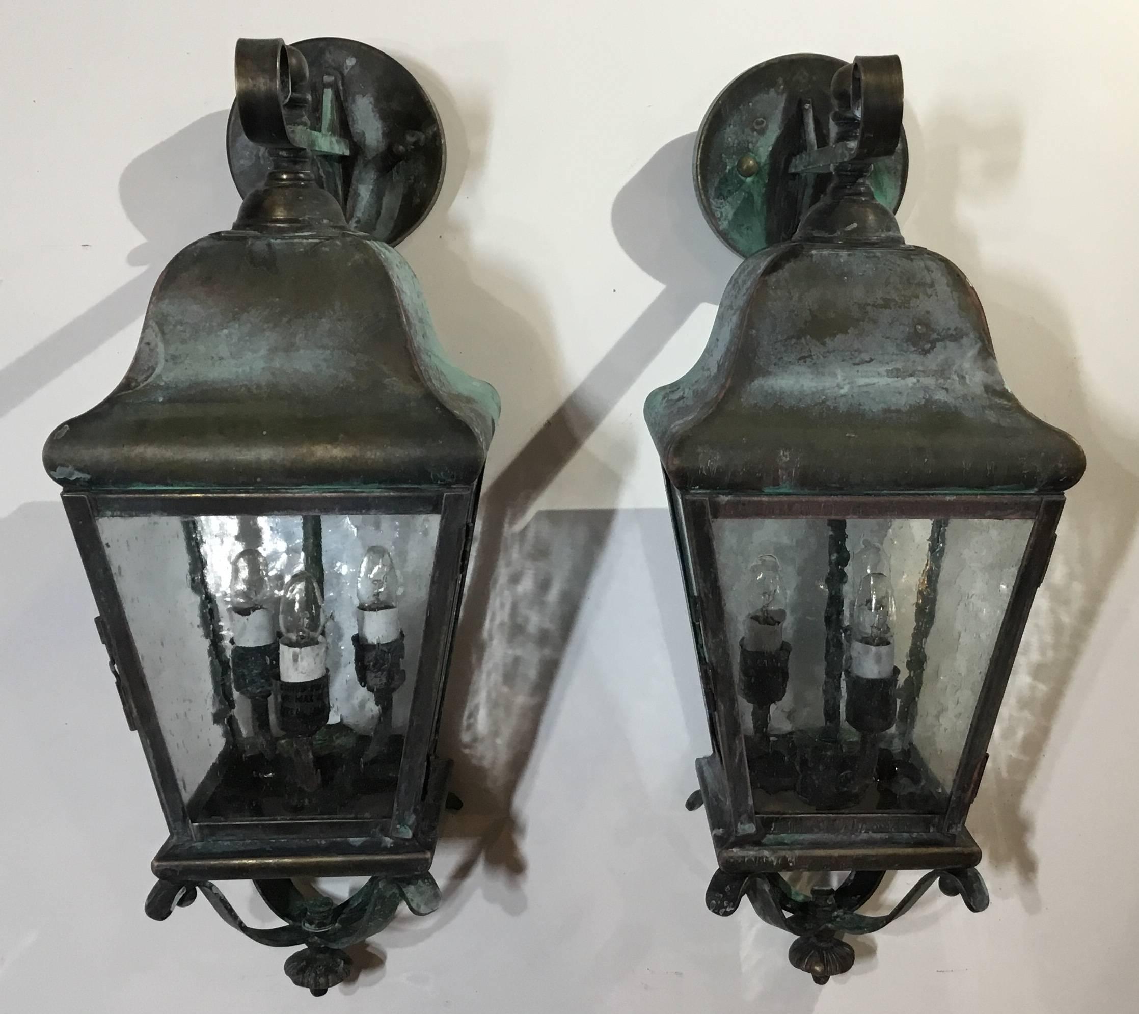 Elagent pair of wall lanterns handcrafted from solid brass with three 40/watt lights each, suitable for wet locations, up to US code UL approved.