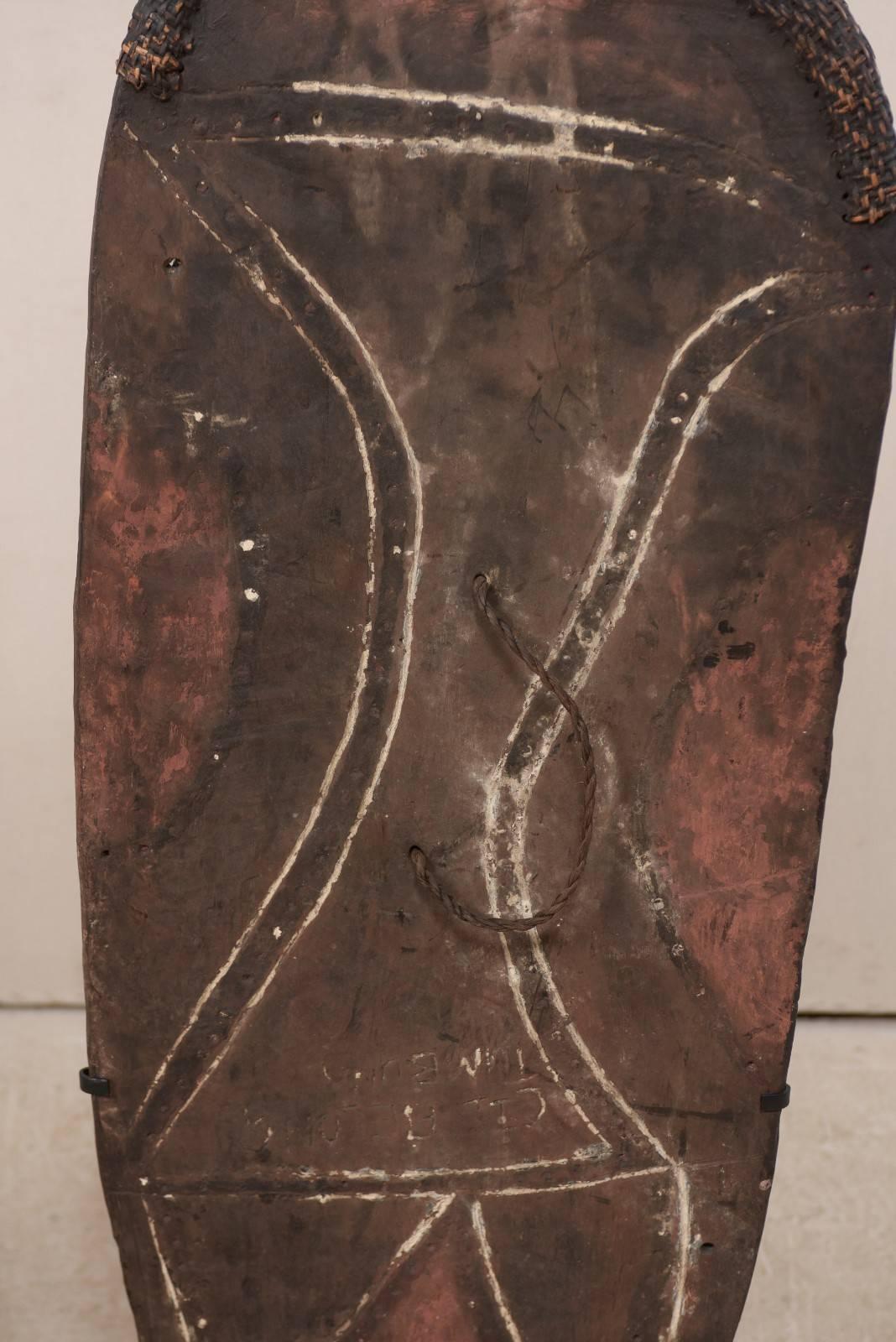 Papuano Coppia di scudi da guerra in legno intagliato Mendi di Papua Nuova Guinea su supporti personalizzati in vendita
