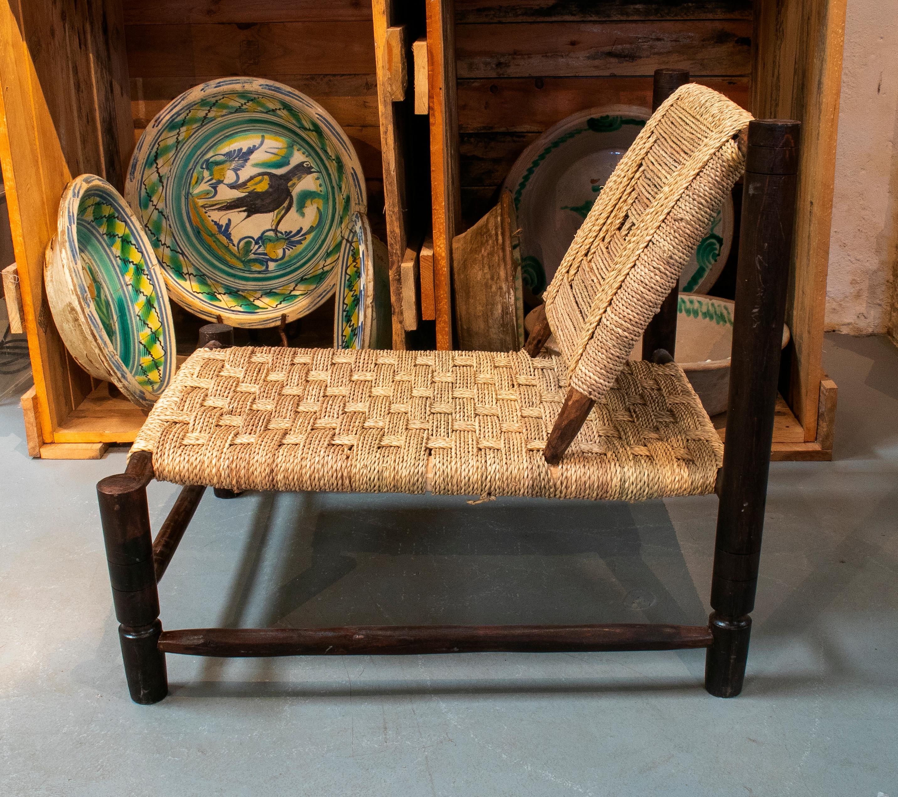 Pair of handmade dark wooden sofa chairs with string rope back and seat.