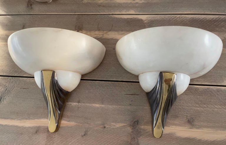 Excellent condition sconces with a marvellous 'cloud pattern' in the stunning alabaster shades.

This French pair of alabaster sconces is beautiful in shape and practical in size. Hand-crafted with a stylish bronze element at the bottom, these