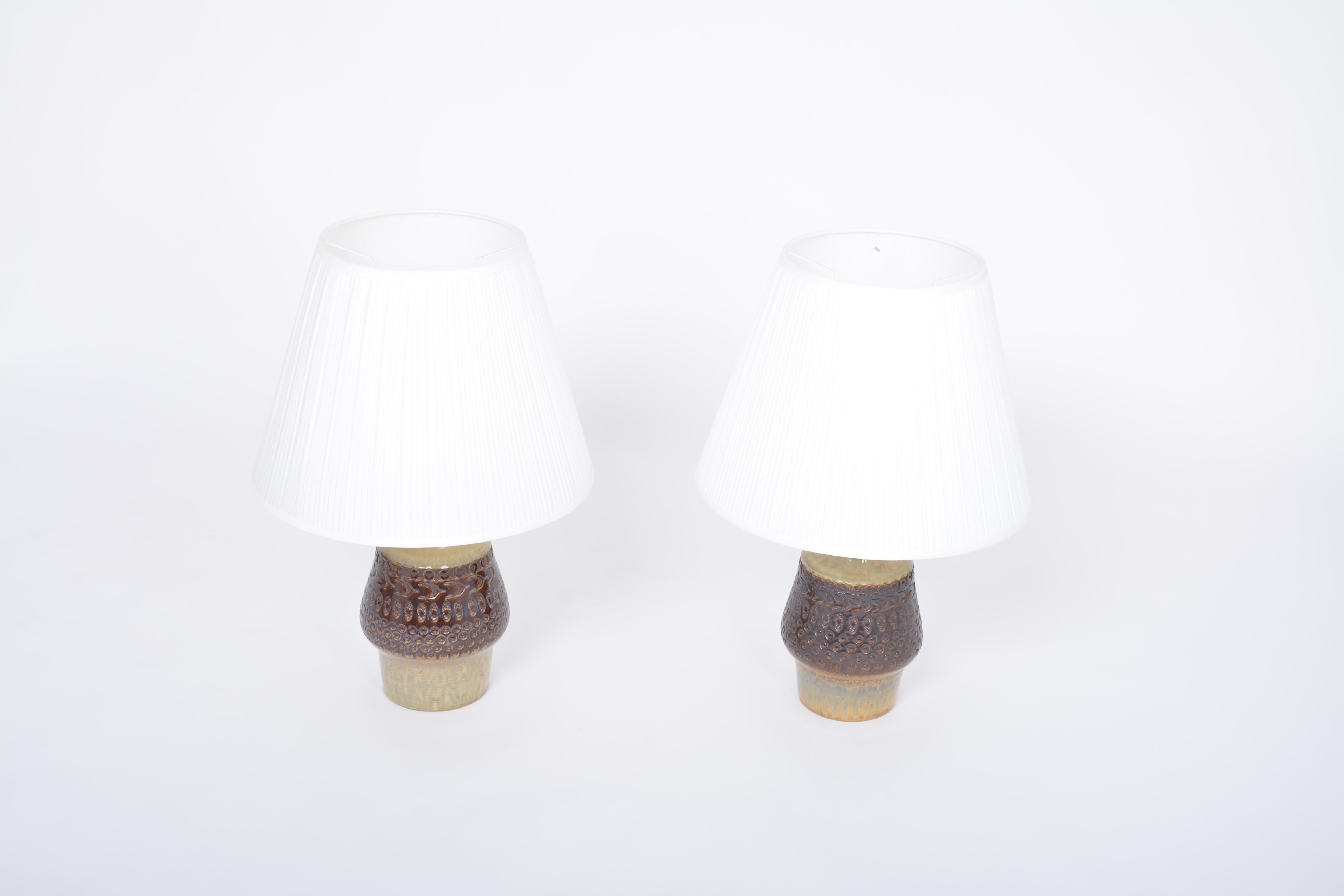 Pair of Handmade Mid-Century Modern Danish Stoneware Table lamps model 3029 by Soholm.

Spectacular pair of tall table lamps made of stoneware with ceramic glazing in various tones of brown and yellow. The base of the lamp features various graphic