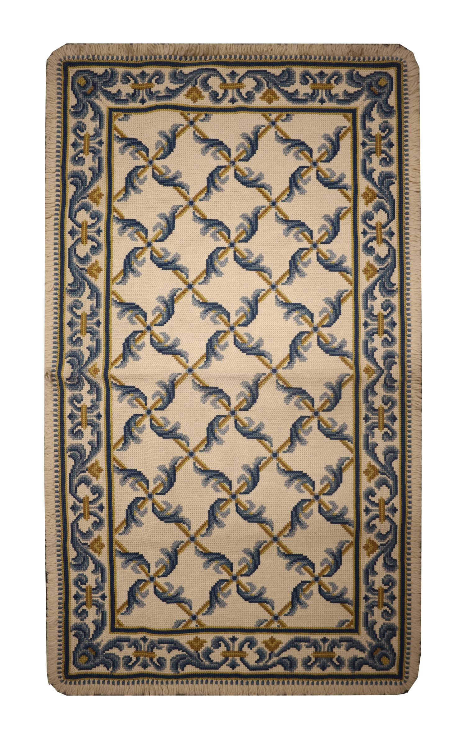 These elegant wool needlepoints are a classic example of a modern Portuguese style rug woven by hand in China in the early 21st century. The design in these pieces has been delicately woven with a symmetrical pattern made up of blue and mustard