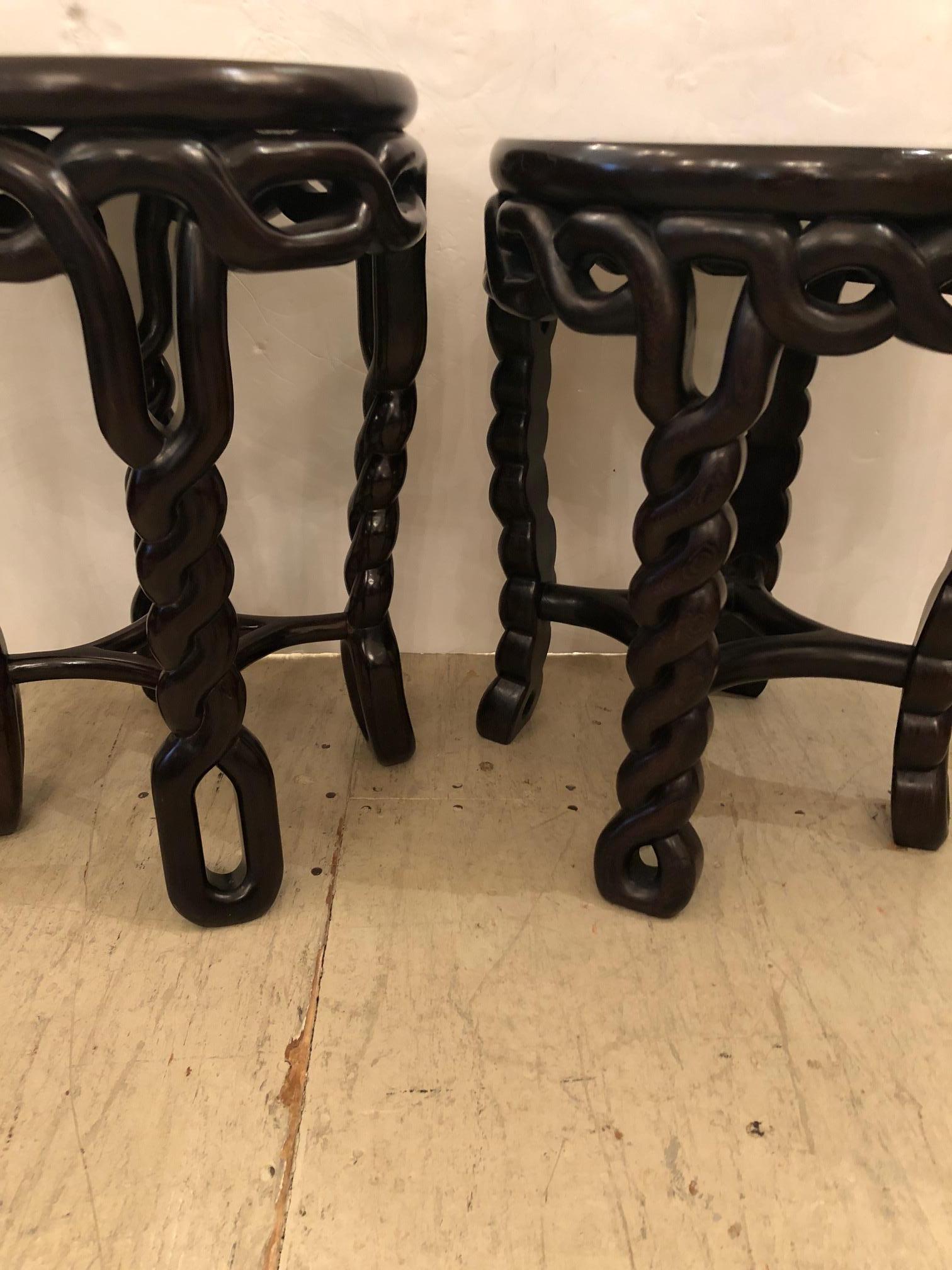 A stunning pair of exotic wood round side or end tables with slightly varying braided rope motife legs, one table is an inch higher -18 inches and 19 inches. They are very solid, heavy and beautifully hand carved wood with a dark finish.
The wood