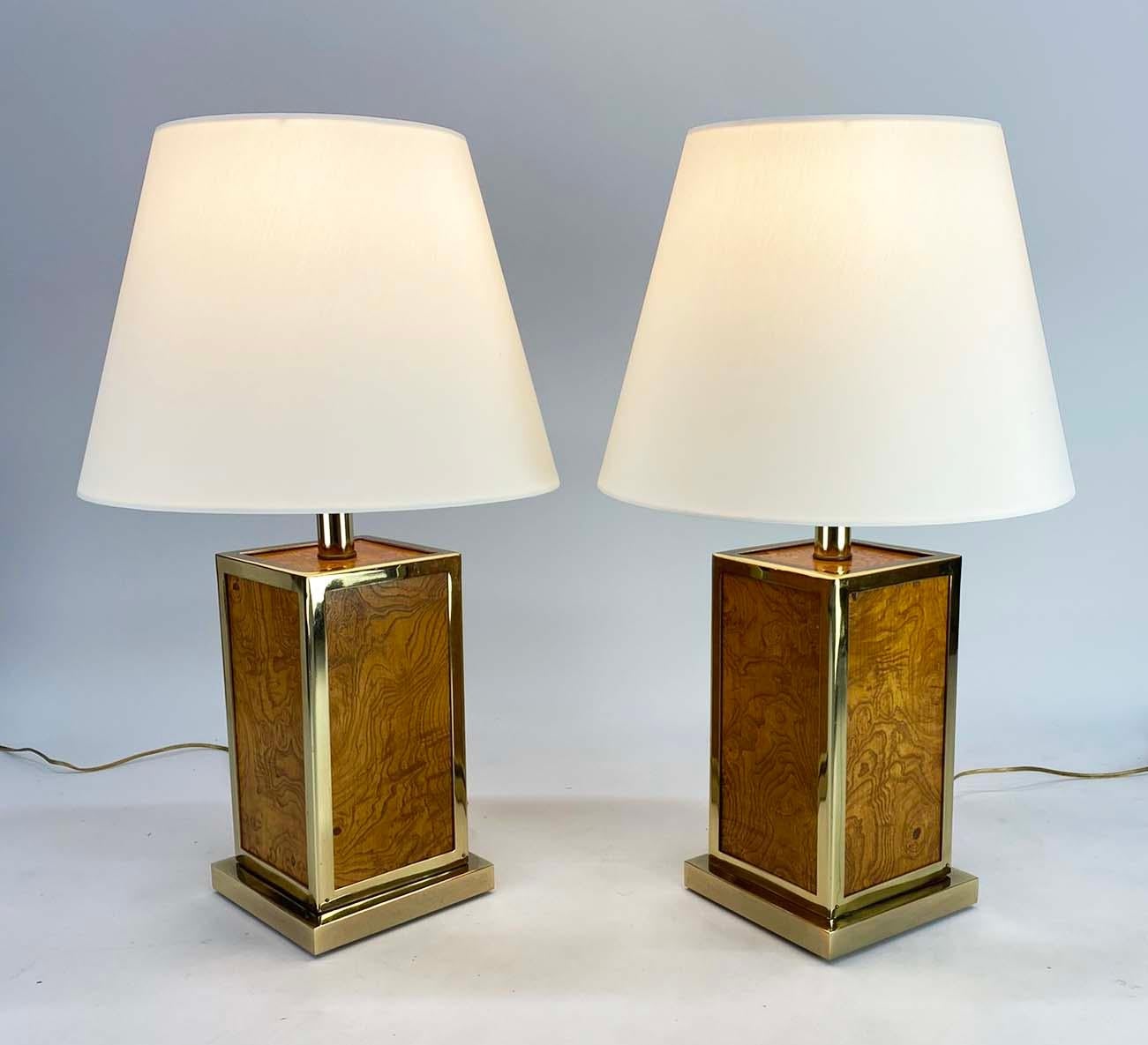 Si tratta di una bella coppia di lampade da tavolo in radica e ottone che si ritiene siano italiane. L'uso dei materiali e la semplicità delle forme sono simili ai design di Romeo Rega, Willy Rizzo e Tommaso Barbi, sebbene il designer americano Milo