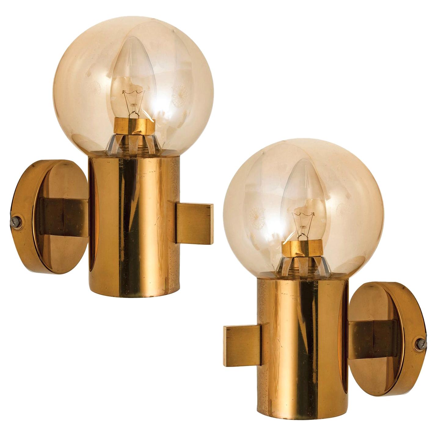This stunning pair of brass wall light with smoked glass bowls and gold-plated fittings was produced in the 1970s by Hans-Agne Jakobsson. Design executed with a taste for excellence in craftsmanship.

We offer also a flushmount, up to 5 globes in