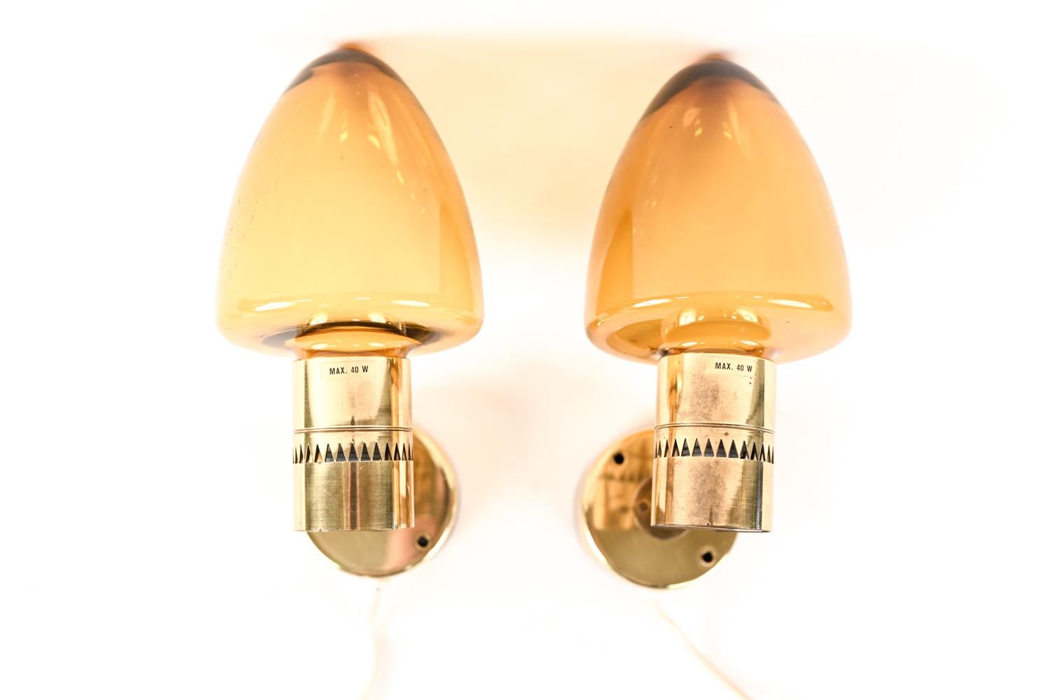 A stylish pair of mushroom form sconces designed by Hans Agne Jakobsson for Markaryd, Sweden. Brass with orange glass globes. Retaining manufacturer's label.