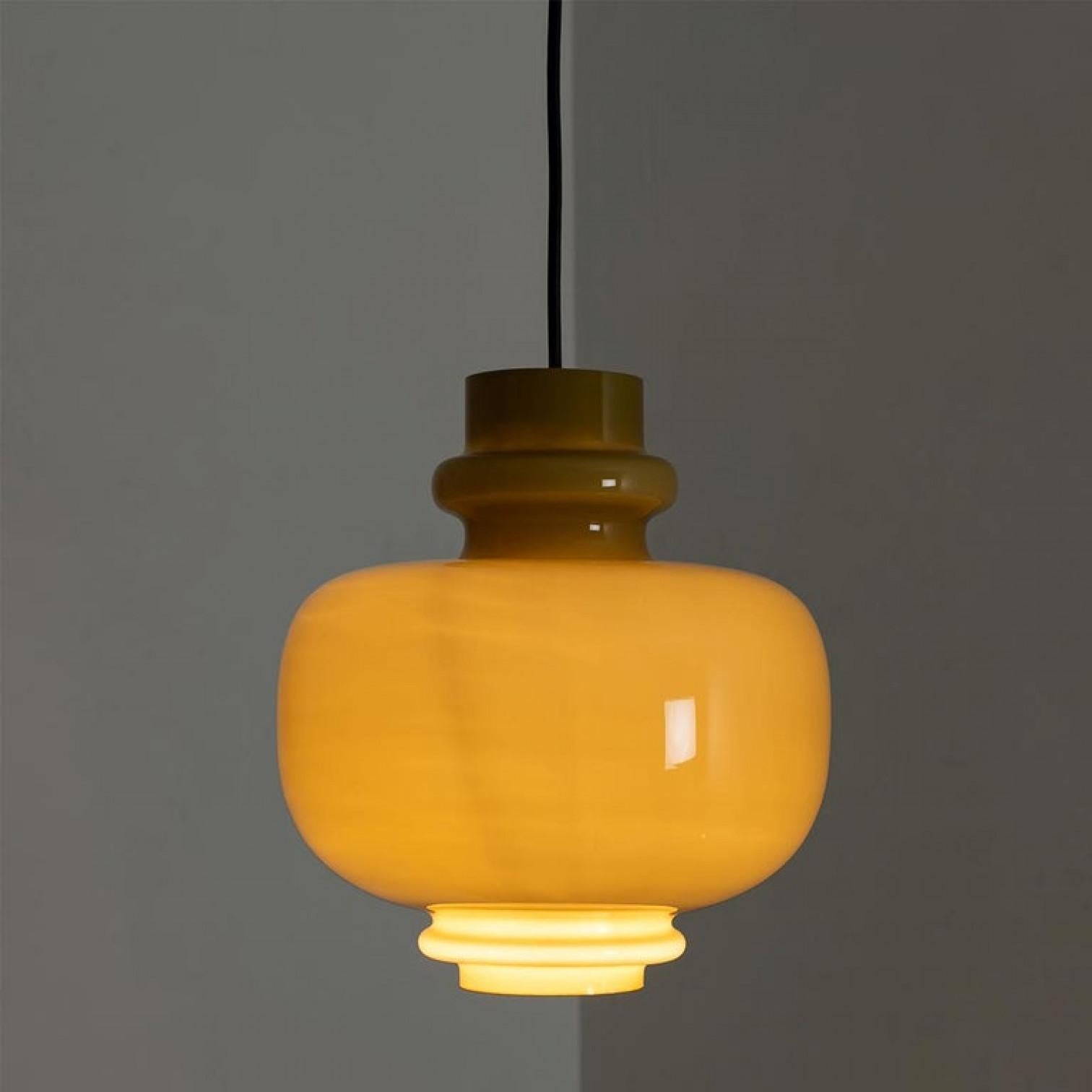 Modernist pendant lamp in light braun-colored opal glass. Designed and designed by H.A. Jacobson for Staff Leuchten, Germany, circa 1960 second half.

Please notice the price is for the pair. We can deliver different canopy's and length /colors of