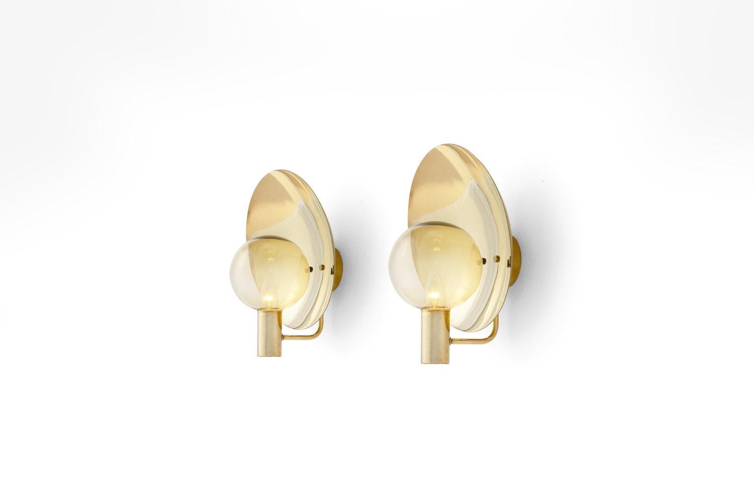 Pair of V180 Hans Agne Jakobsson Wall Lamps with smoked glass shades, Sweden 1960s. Produced by Hans Agne Jakobsson AB ca 1960s - 1970s.

This pleasing pair of brass wall lights have a minimalistic yet refined aesthetic. The light from the slightly