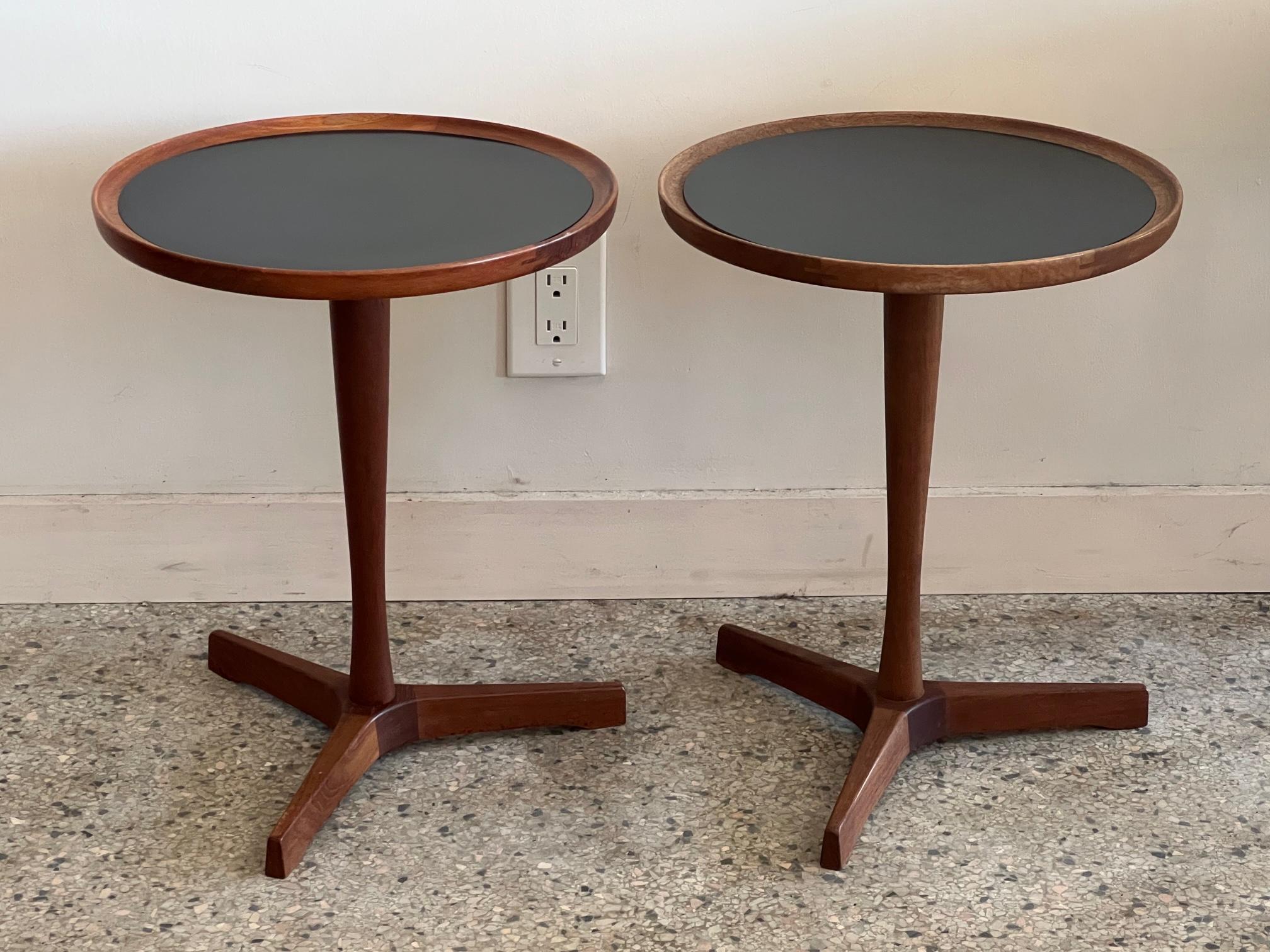 A great pair of Classic gueridons or occasional tables by Hans C. Andersen. Made in Denmark, circa 1960s, teak. The tops dismount for easier shipping. This version has the black laminate tops-both tables are signed.