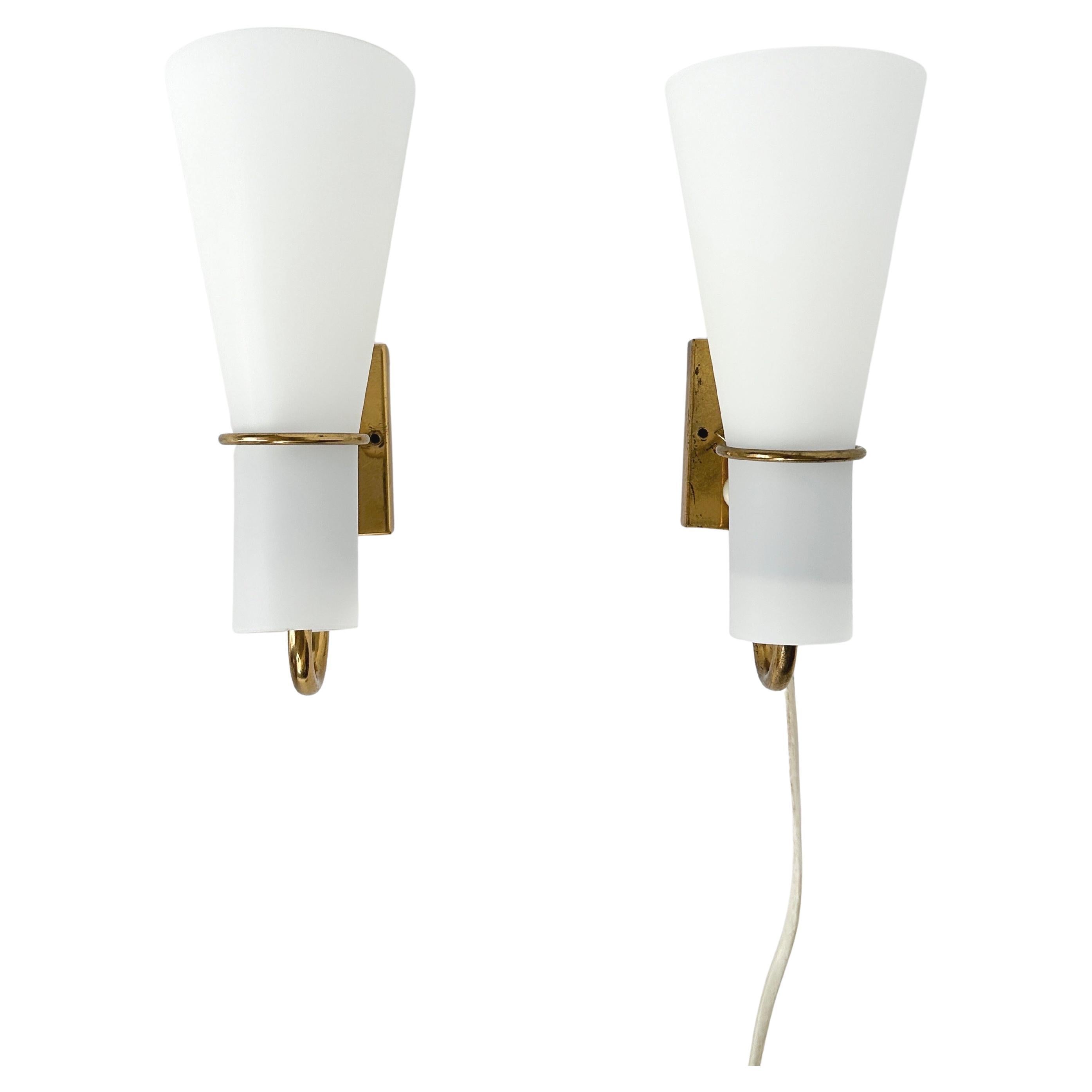 Rare paire d'appliques, attribuée à Hans Bergström et produite en Suède par ASEA dans les années 1950.

Laiton massif avec abat-jour en verre opalin satiné.

L'une d'entre elles comporte un interrupteur installé sur le luminaire en laiton, tandis