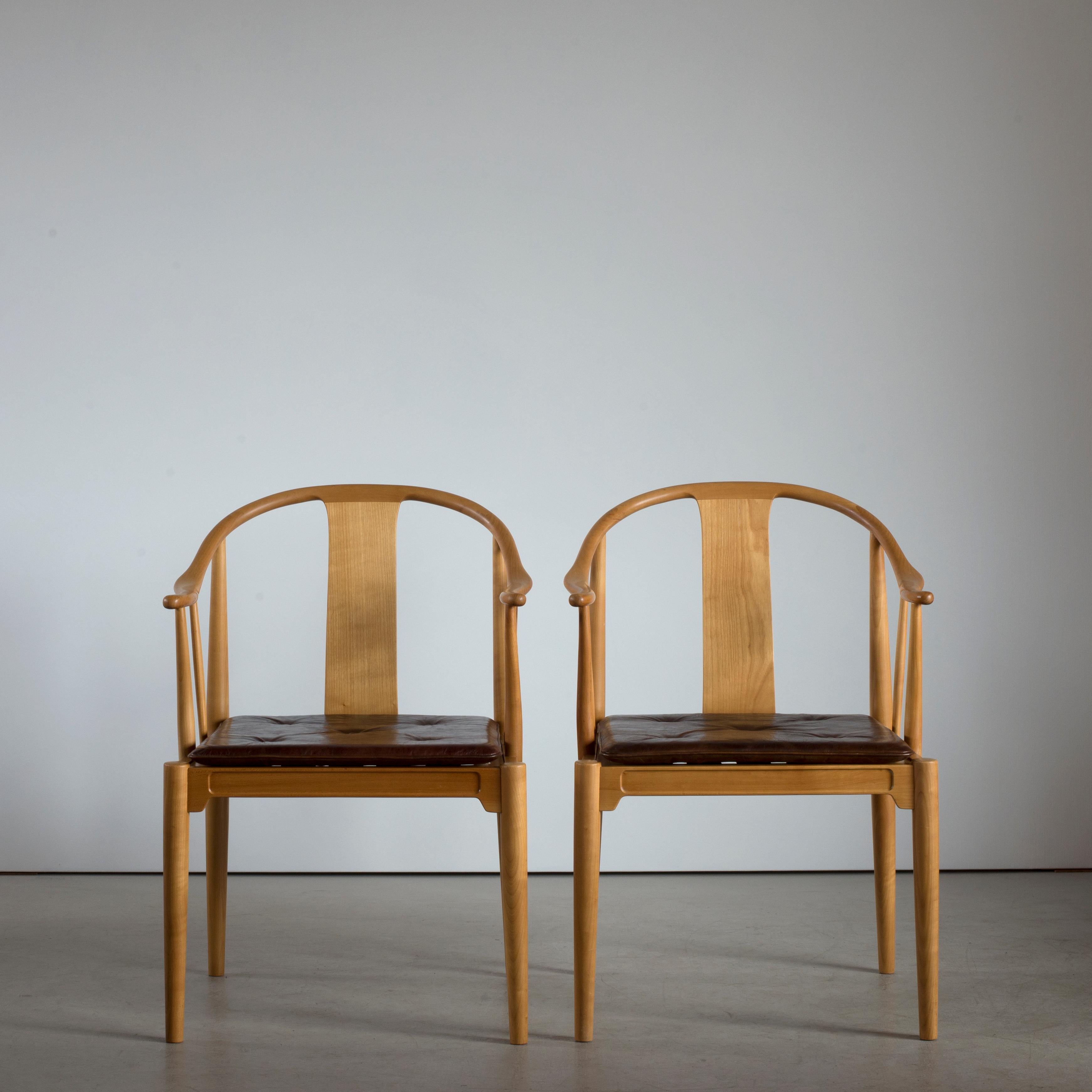 Hans J. Wegner Chinesische Stühle aus Kirschholz. Lose Sitzkissen mit rotem Leder gepolstert, mit Knöpfen versehen. Ausgeführt von Fritz Hansen, 1969.

Rückseite mit Papieretikett Fritz Hansen, DÄNEMARK.

  