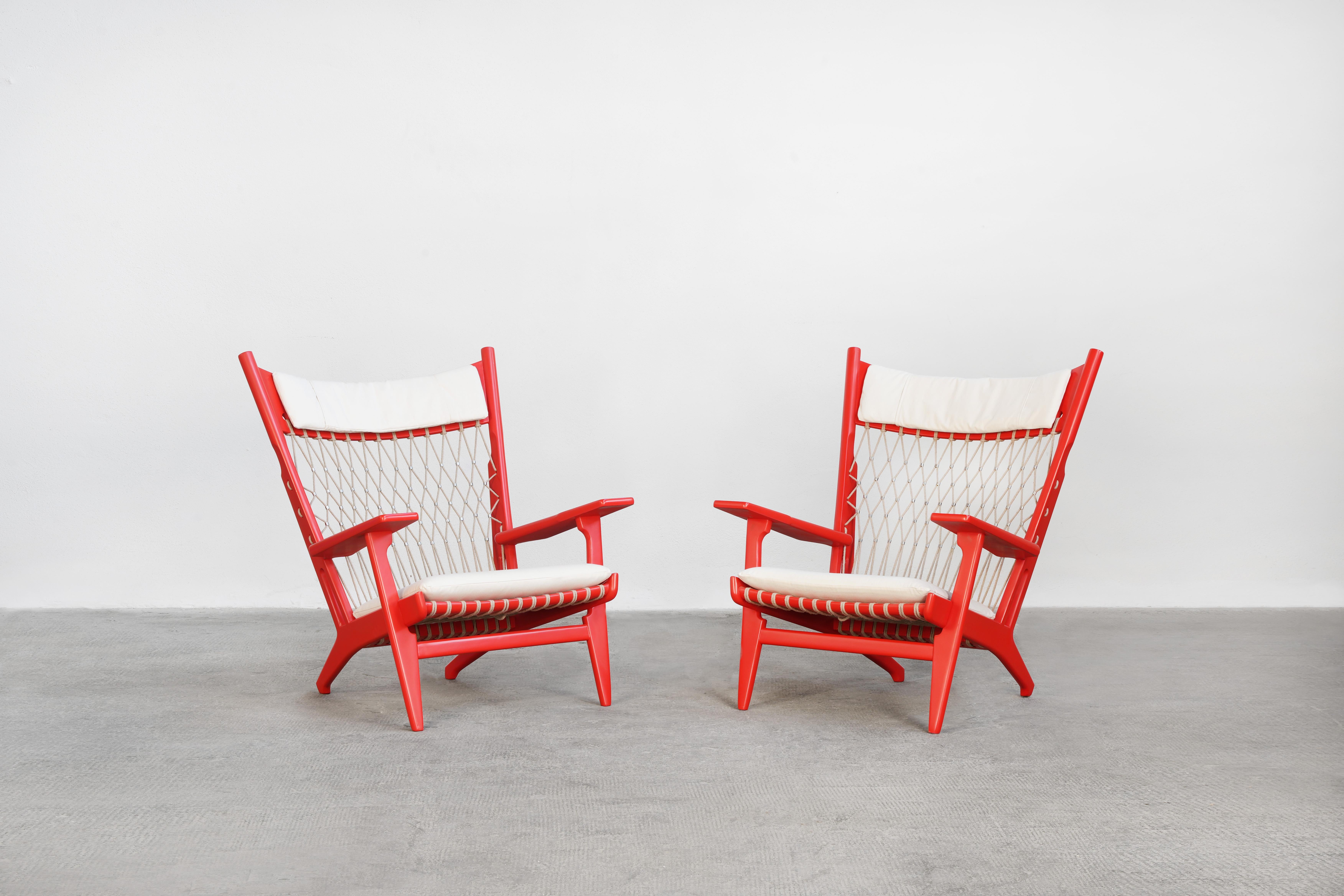Beautiful pair of Danish easy chairs designed by Hans J. Wegner and manufactured by Johannes Hansen. 
These rare lounge chairs come in excellent restored condition with loose seat and neck cushions upholstered with high-quality fabric in cotton.