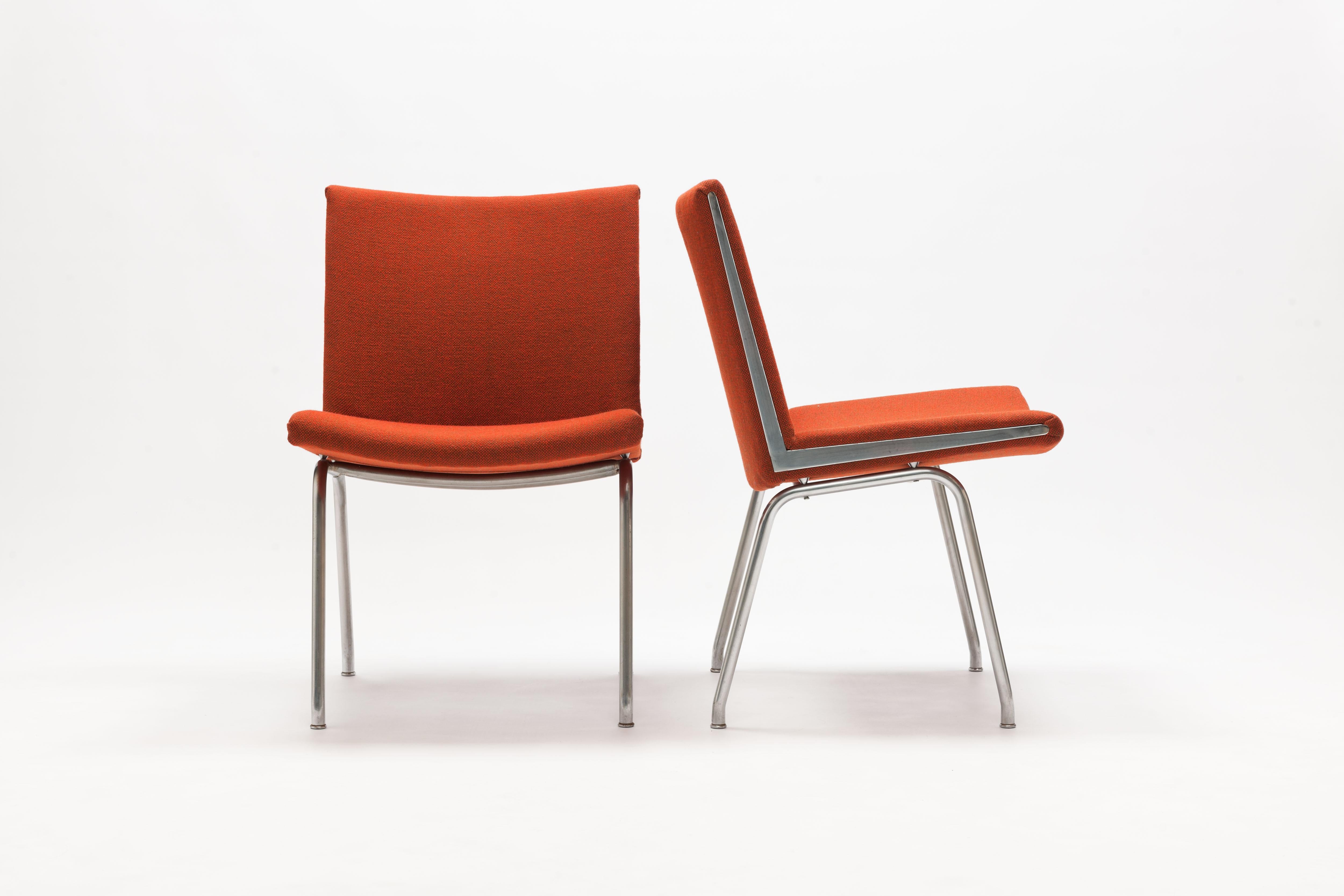 Pair of Hans Wegner AP37 'Airport' Chairs by A.P. Stolen Denmark, 
Exceptional modern designed chairs on steel frames with sharp triangle shape chrome details on both sides of each seat. 
Seats are upholstered in a red Hallingdal fabric. This is a
