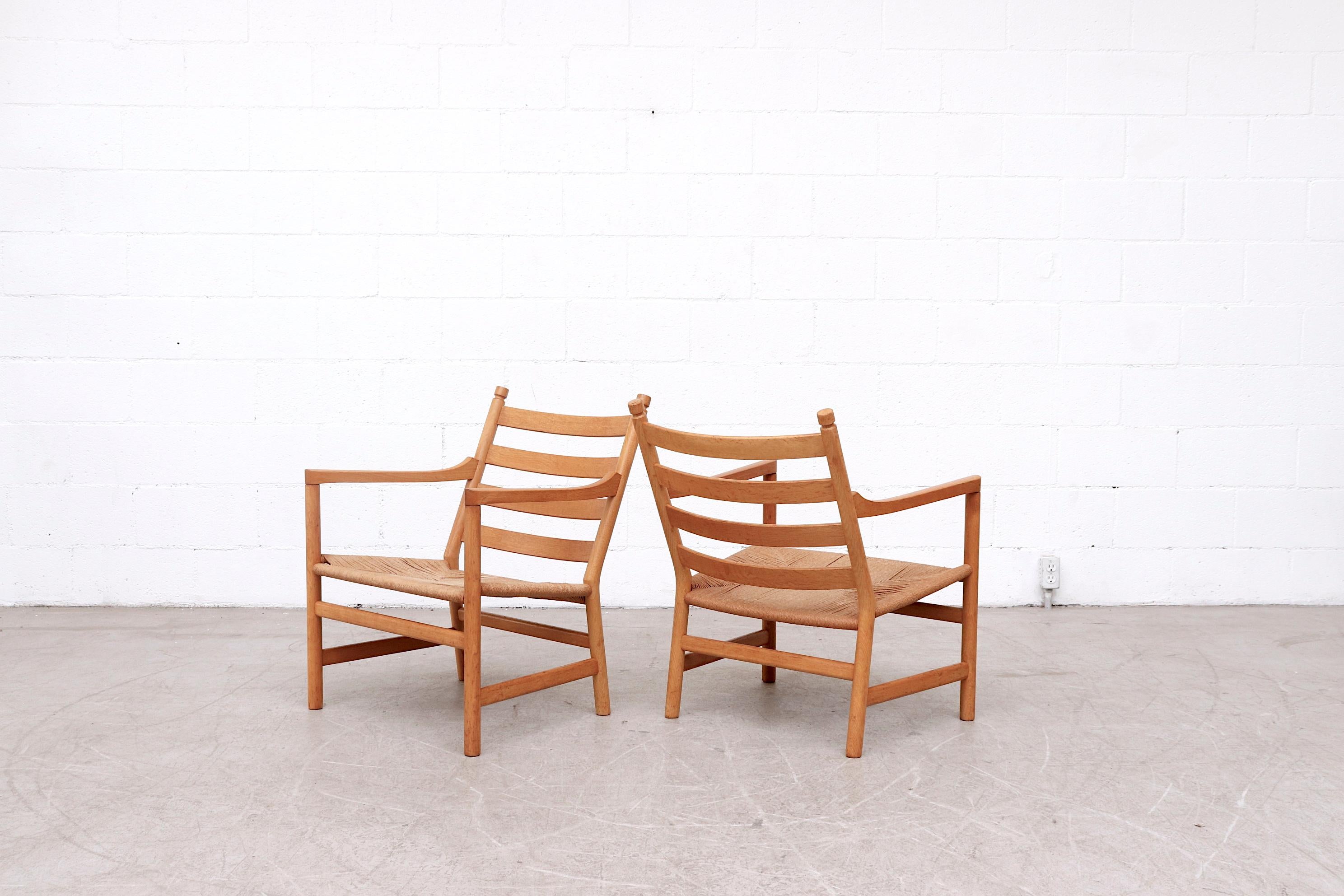 Pair of midcentury 'CH44' lounge chairs from 1965 by Hans J. Wegner for Carl Hansen & Son. Inspired by American shaker furniture, The CH44 lounge chair is made from solid oak and features paper cord woven seating. The frames are in good original