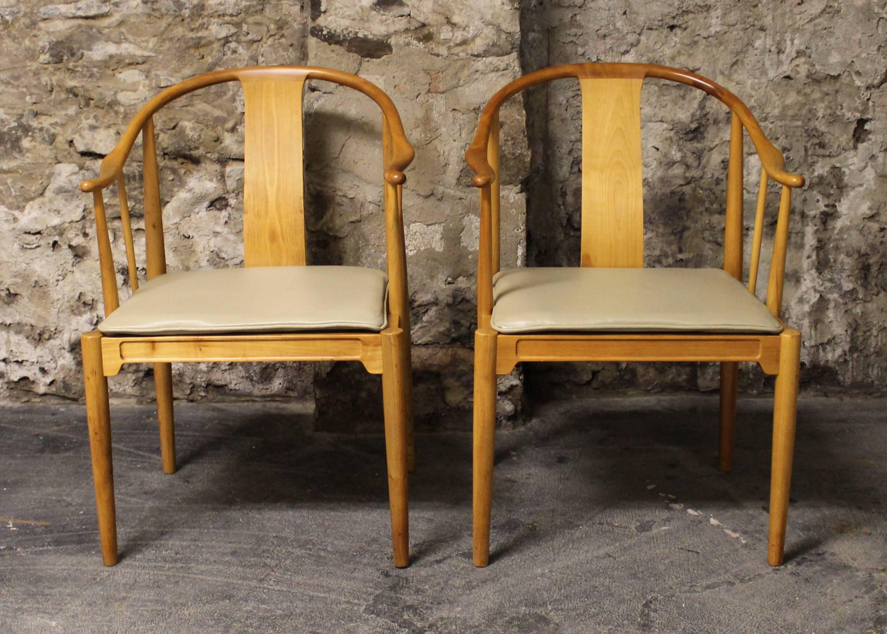 Beautiful pair of 'China' chairs by Hans J. Wegner for Fritz Hansen. These Classic Mid-Century Modern chairs are made from cherrywood and feature newly upholstered leather seats. The China chair was designed by Hans J. Wegner, in 1944 and it stands