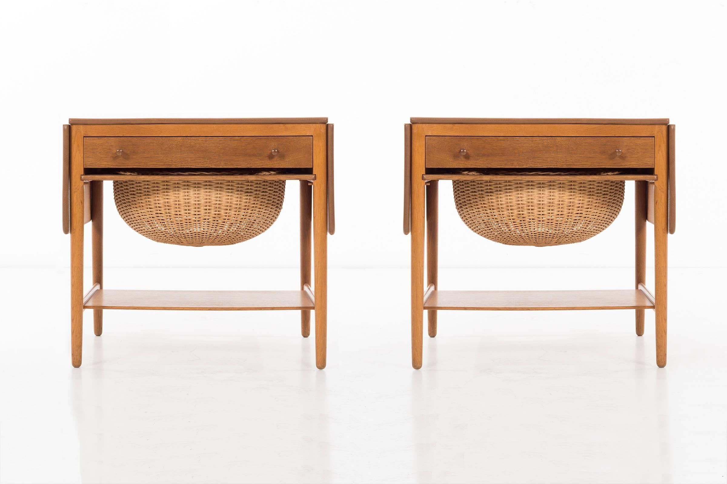 Tables feature drawers with knob pulls and storage baskets, two 10-inch drop-leaves; they measures forty-seven inches when fully extended.
Stained oak, cane Signed with branded manufacturer's mark to underside: [Fabrikat: Andr. Tuck Arkitekt: Hans