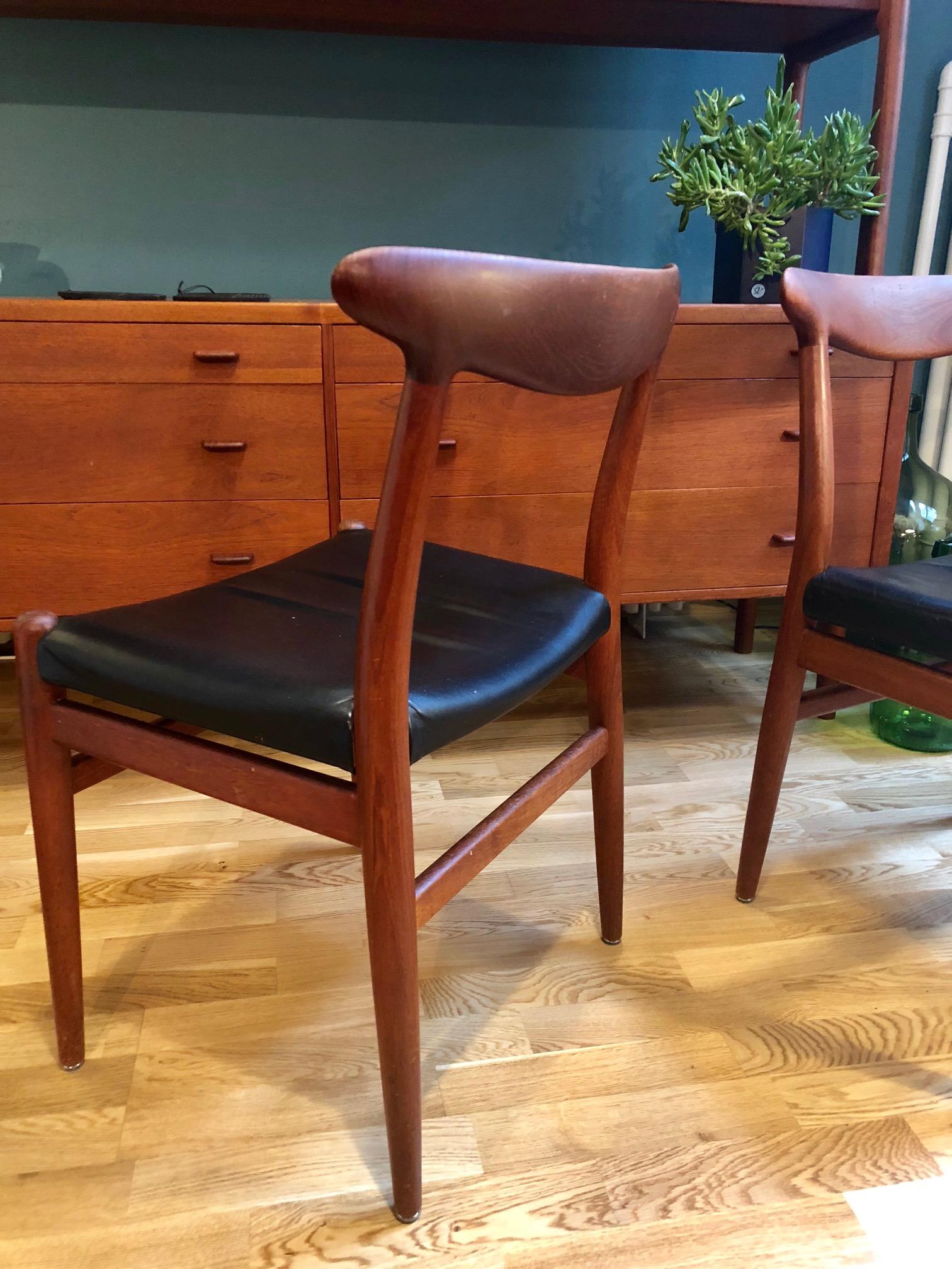 Beautiful, rare set of 2 Hans Wegner chairs made of teak and black leather. Comfortable and well preserved. Model W2 Production by C.M. Madsen Denmark 1953. Beautiful processing of teak. Marked.
 