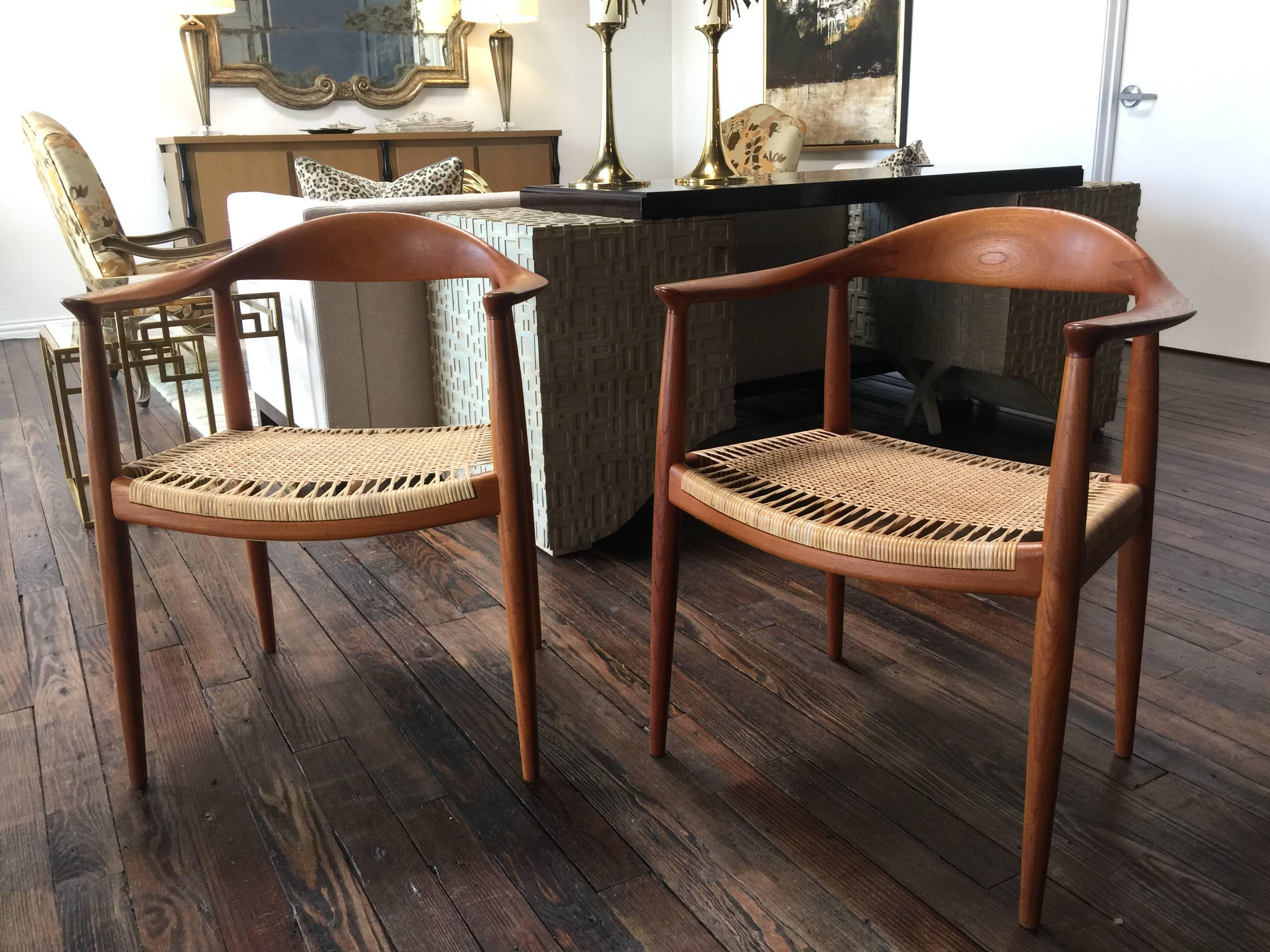 Beautiful pair of round chairs by Hans Wegner. Cane seats. One seat was replaced so a slight variation in color that will disappear over time. Both show very well.