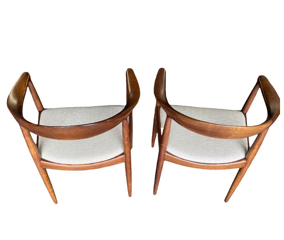Pair of matched Hans J. Wegner round chairs. Stunning wood, elegant textile. Sturdy and solid. Signed and guaranteed authentic. In good even condition.
