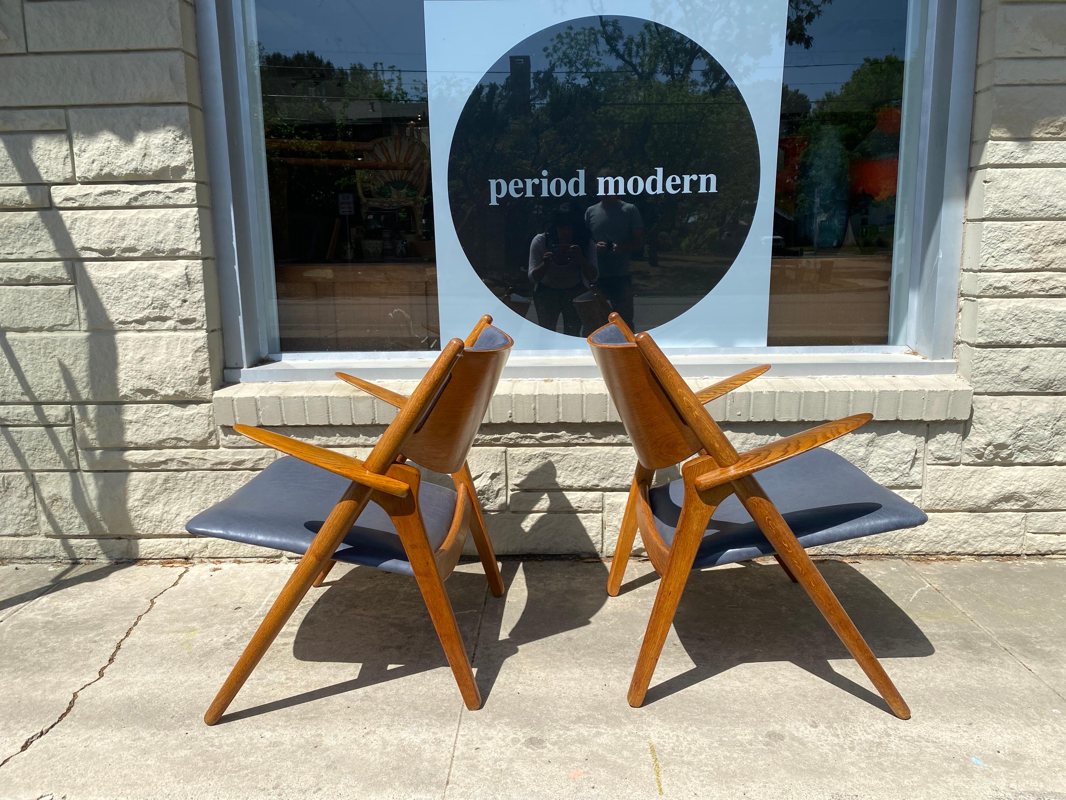 Pair of iconic Danish modern Sawbuck CH28 chairs by one of the most influential designers of the 20th century, Hans Wegner for Carl Hansen & Son of Denmark. The sawbuck chair is known for its clean lines and unique look. This pair of Mid-Century