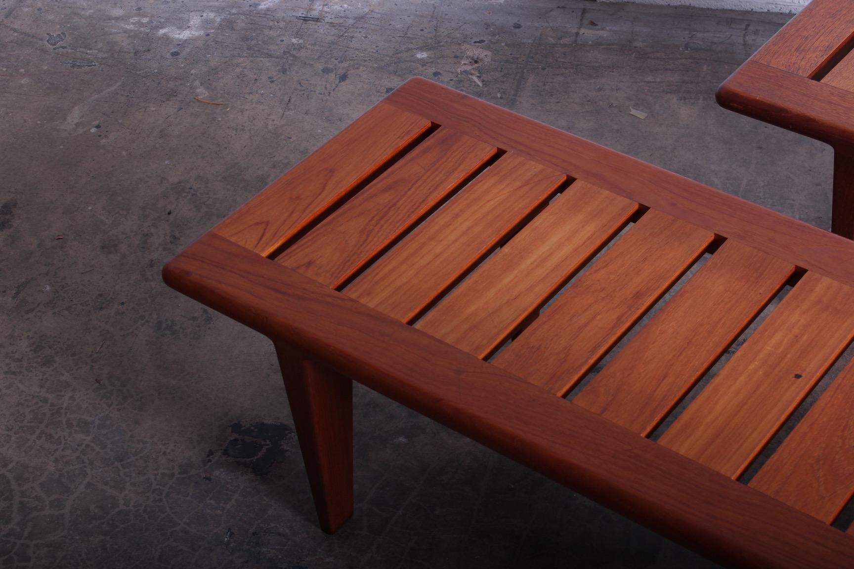 A pair of solid teak benches designed by Hans Wegner for Johannes Hansen.