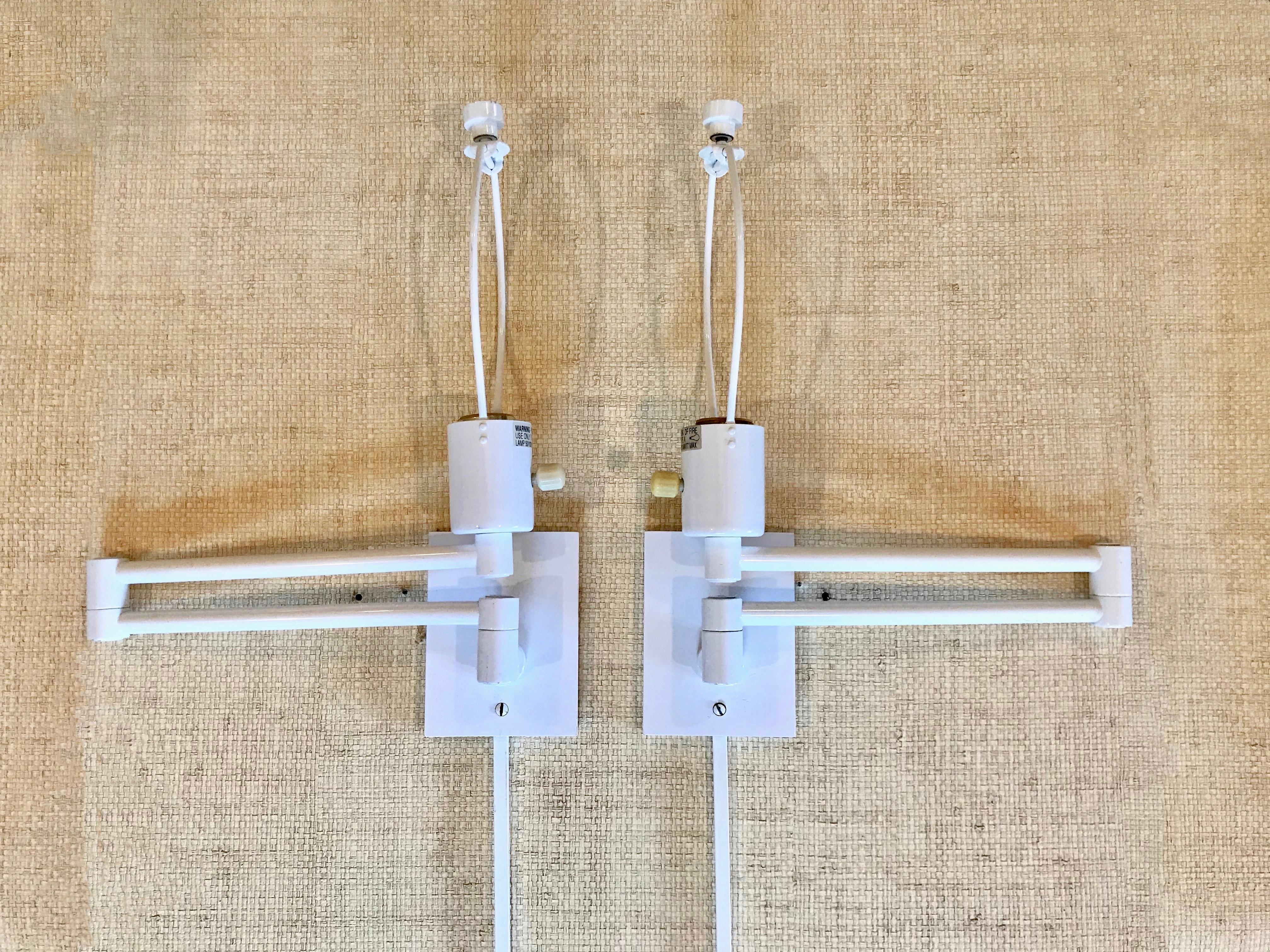 Vintage pair of Hansen brass double swing arm wall lamps or sconces in original white lacquered finish. Style # L1706 designed by George W. Hansen, this wall sconce has become a staple in interior design since it was introduced. This version is wall