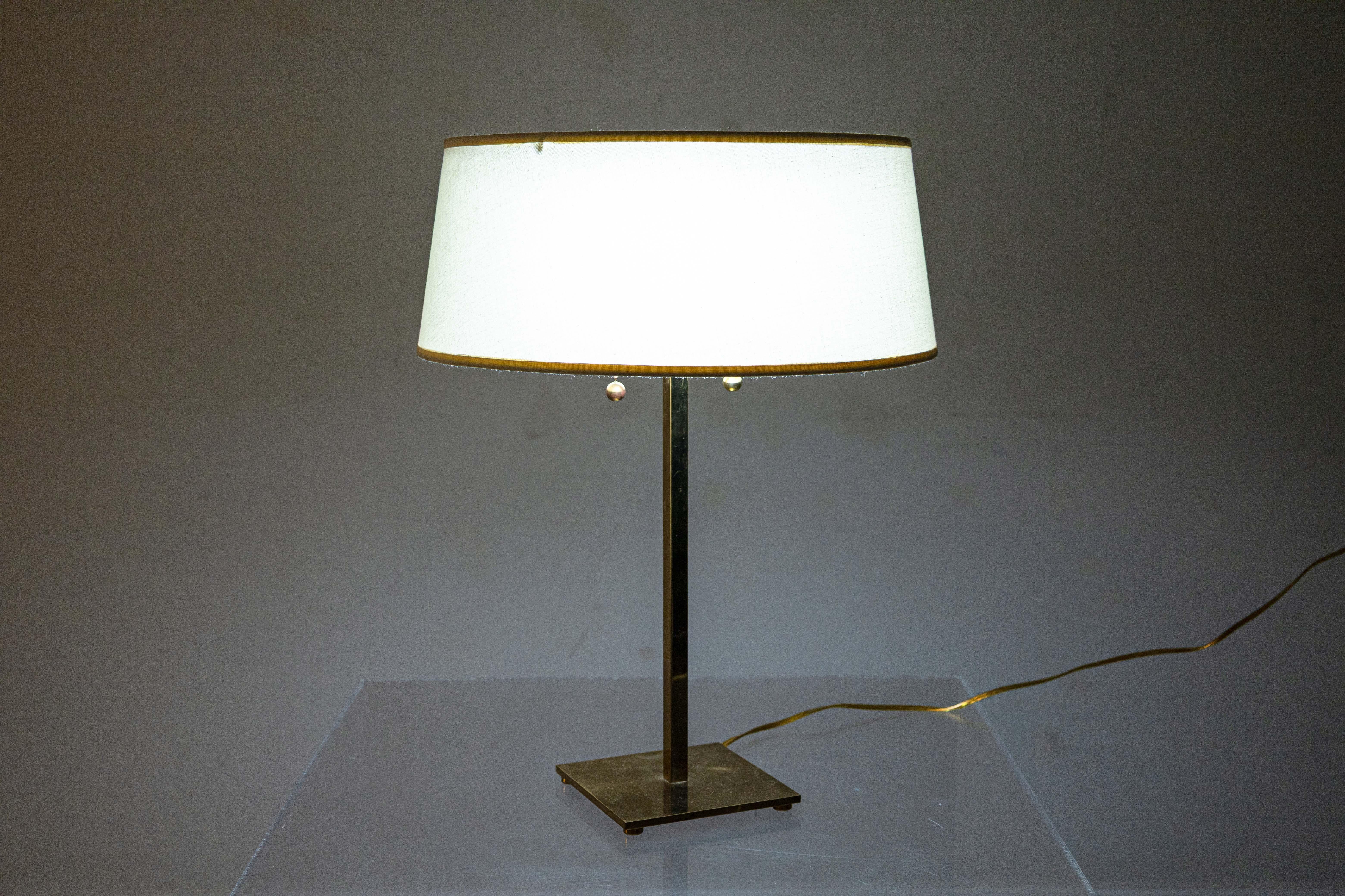 Ein Paar Hansen New York Tischlampen aus Messing. Dieses schöne Set moderner Tischlampen aus der Mitte des Jahrhunderts zeichnet sich durch eine saubere Messingkonstruktion aus. Sie hat einen quadratischen Sockel mit kleinen Messingfüßen, der zu