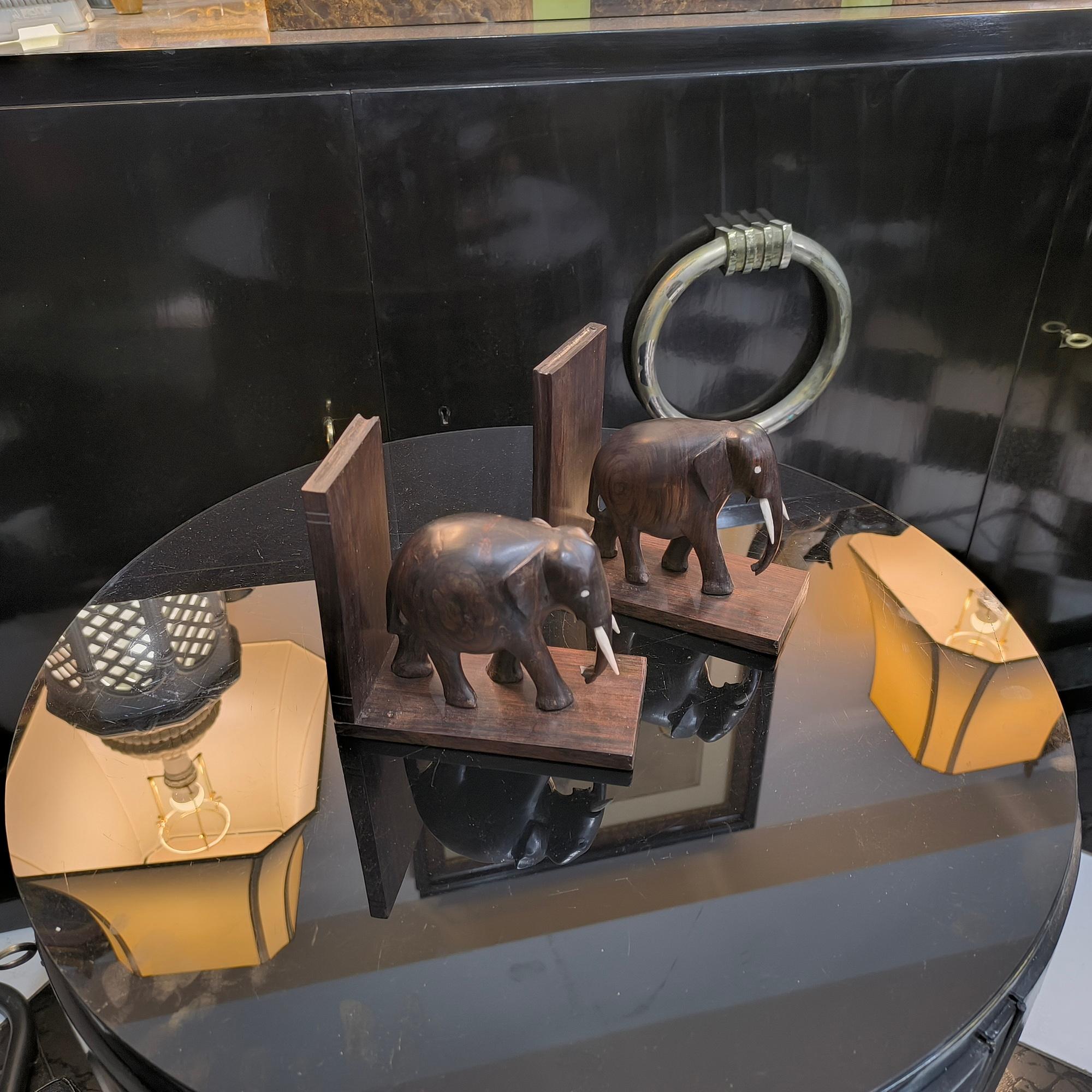 Si tratta di una coppia di fermalibri a forma di elefante vintage. Sono realizzati in un bellissimo legno duro, intagliati a mano e dotati di occhi e zanne in osso. 

Sono in ottime condizioni d'uso. Sono deliziosi per il lettore abituale di romanzi