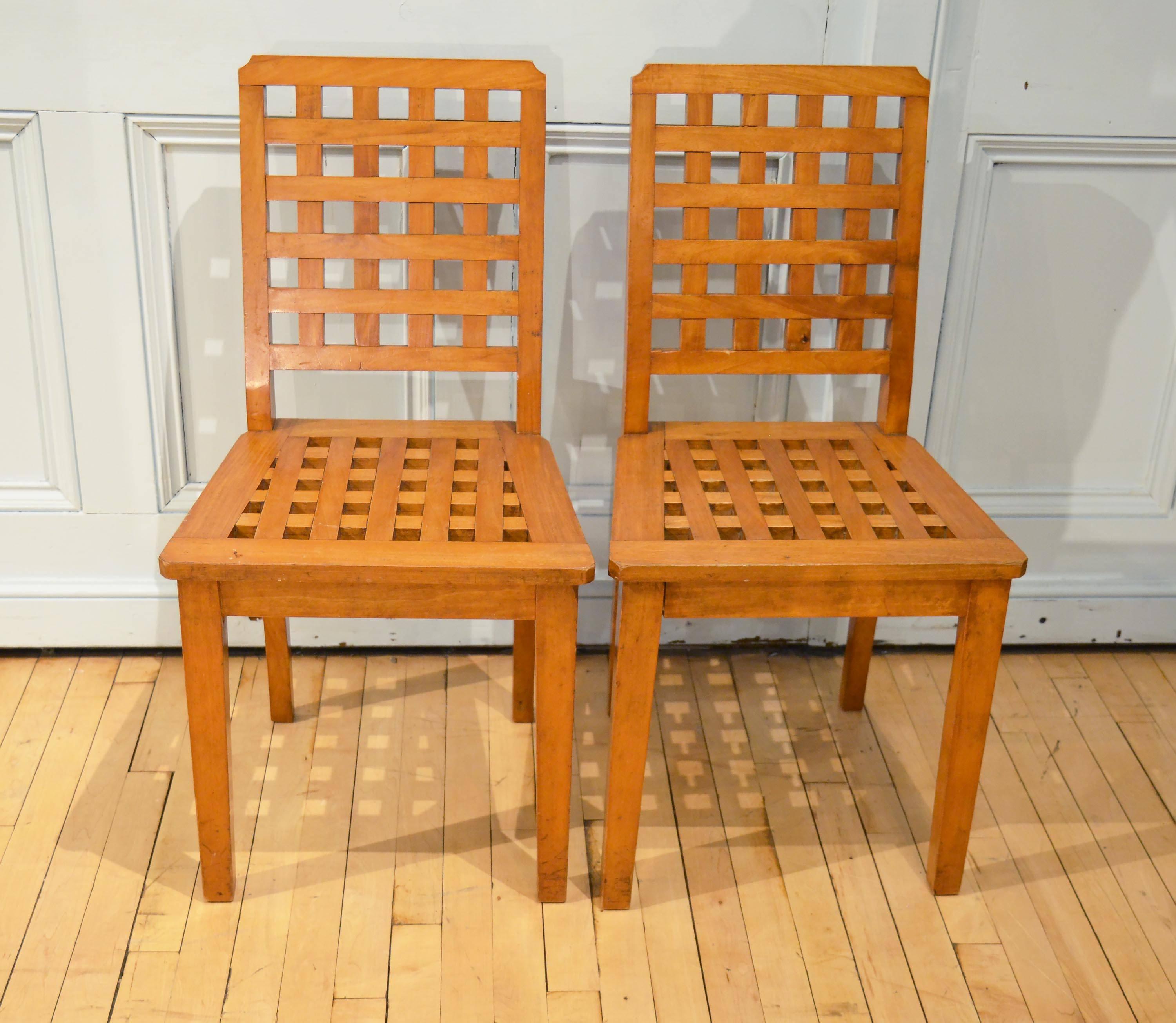 These very attractive and sturdy English side chairs are made of satinwood and mid-20th century in date. The chairs have a stylish lattice pattern on the back splat and seat. Each chair measures 18 in - 45 cm in width, 19 in - 48 cm in depth and 34