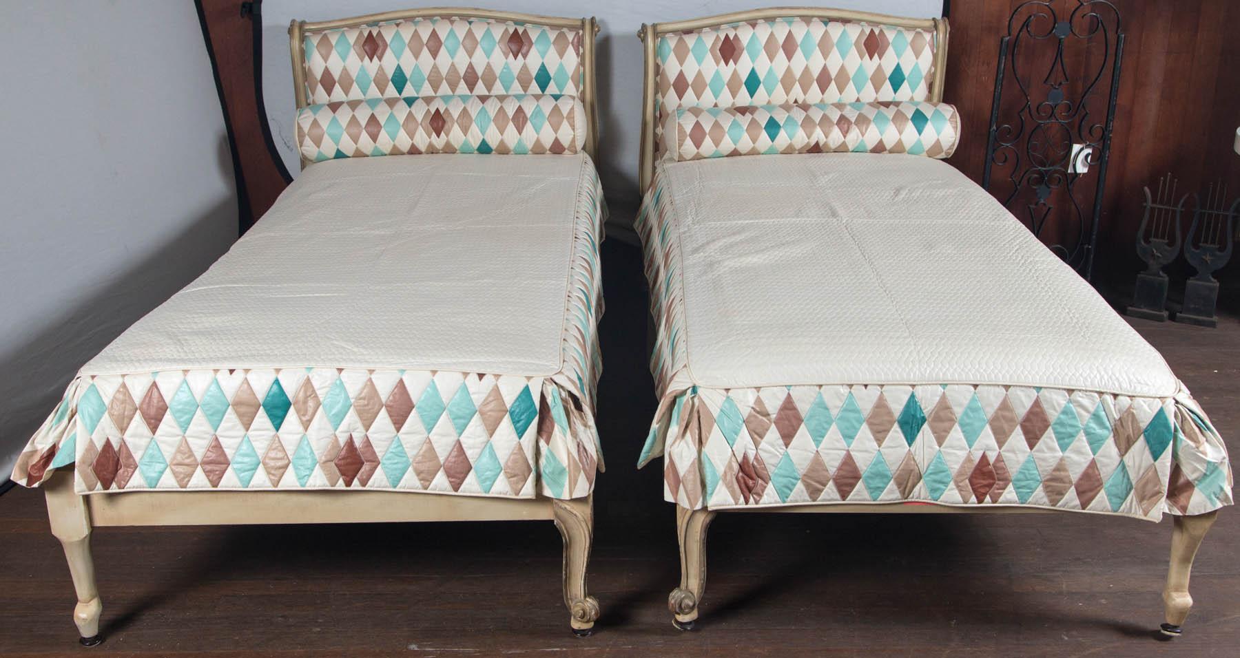 Pair of French Louis XV style twin beds with harlequin fabric upholstered headboards, neck rolls, and bedspreads. Fabric is taupe, aqua, and teal.
Bed frames are two toned off white. Bed height is 21 inches.