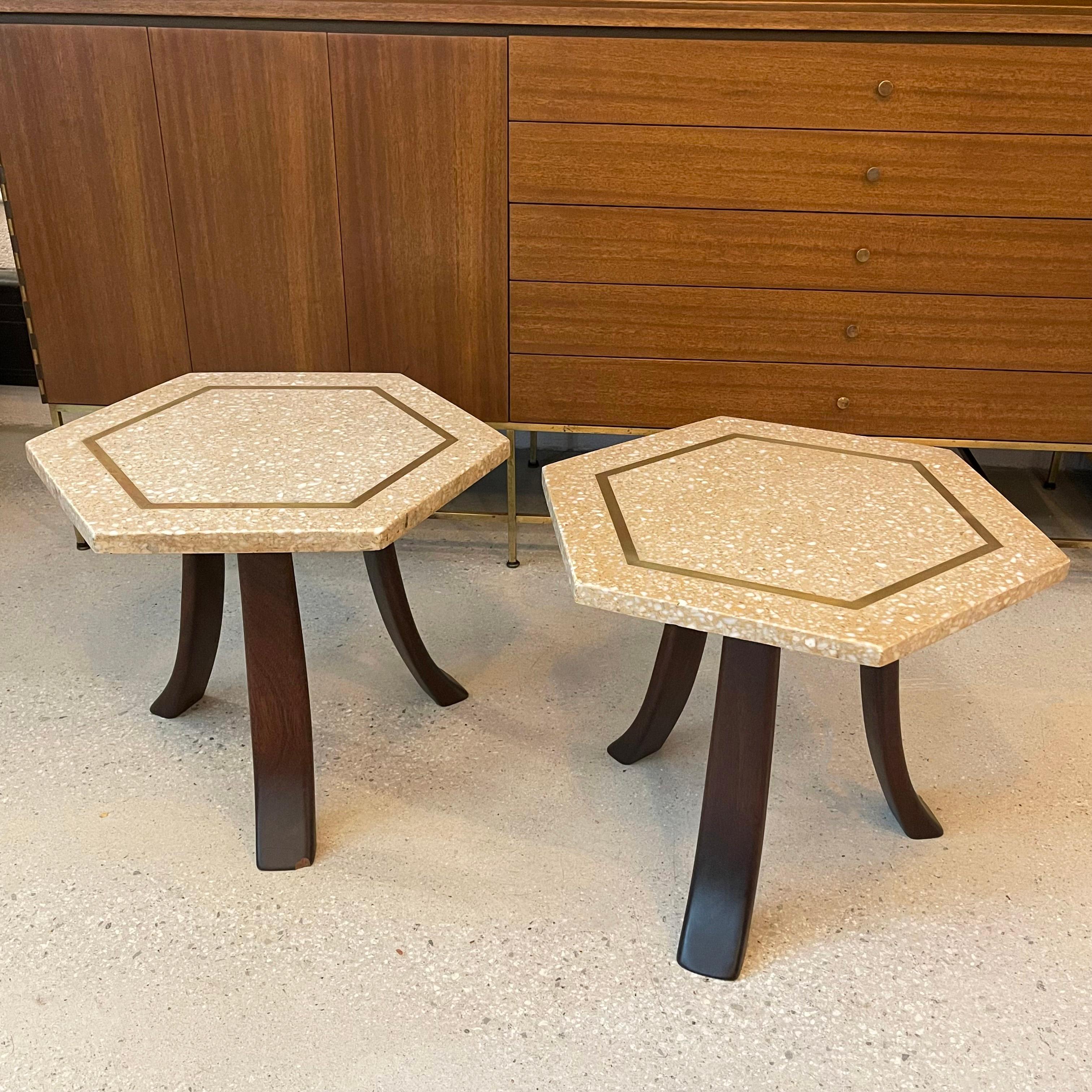 Pair of mid-century modern, Moroccan influenced, side/end tables by Harvey Probber feature hexagonal shaped, terrazzo stone tops with brass inlay on three sloping mahogany legs. The terrazzo tops are a warm hue with contrasting dark mahogany