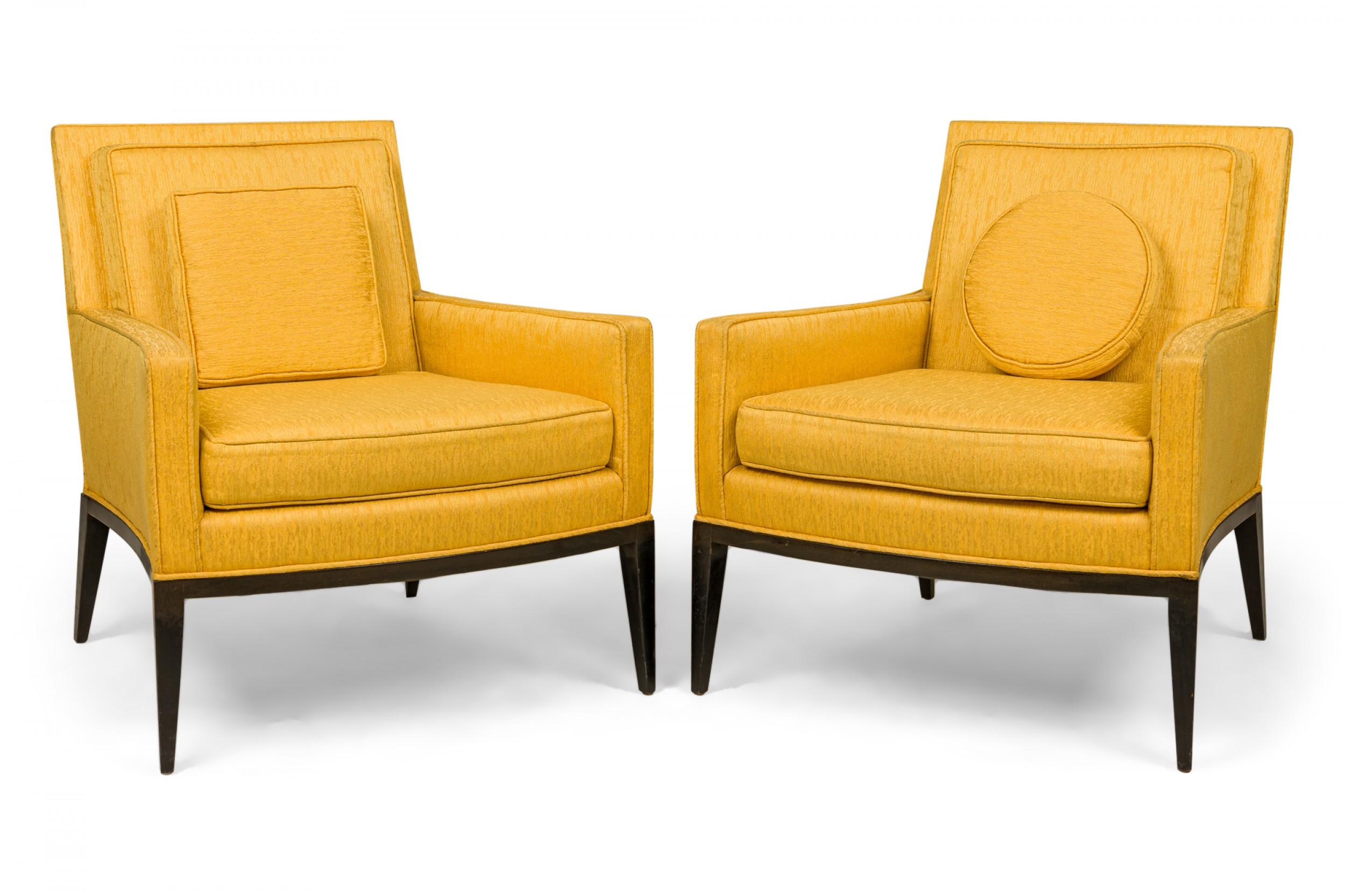 PAIR of American Mid-Century lounge / armchairs with bright yellow fabric upholstery with removable back and seat cushions, one square, and one circular matching throw pillow, resting on ebonized wooden frames with four tapered legs. (HARVEY