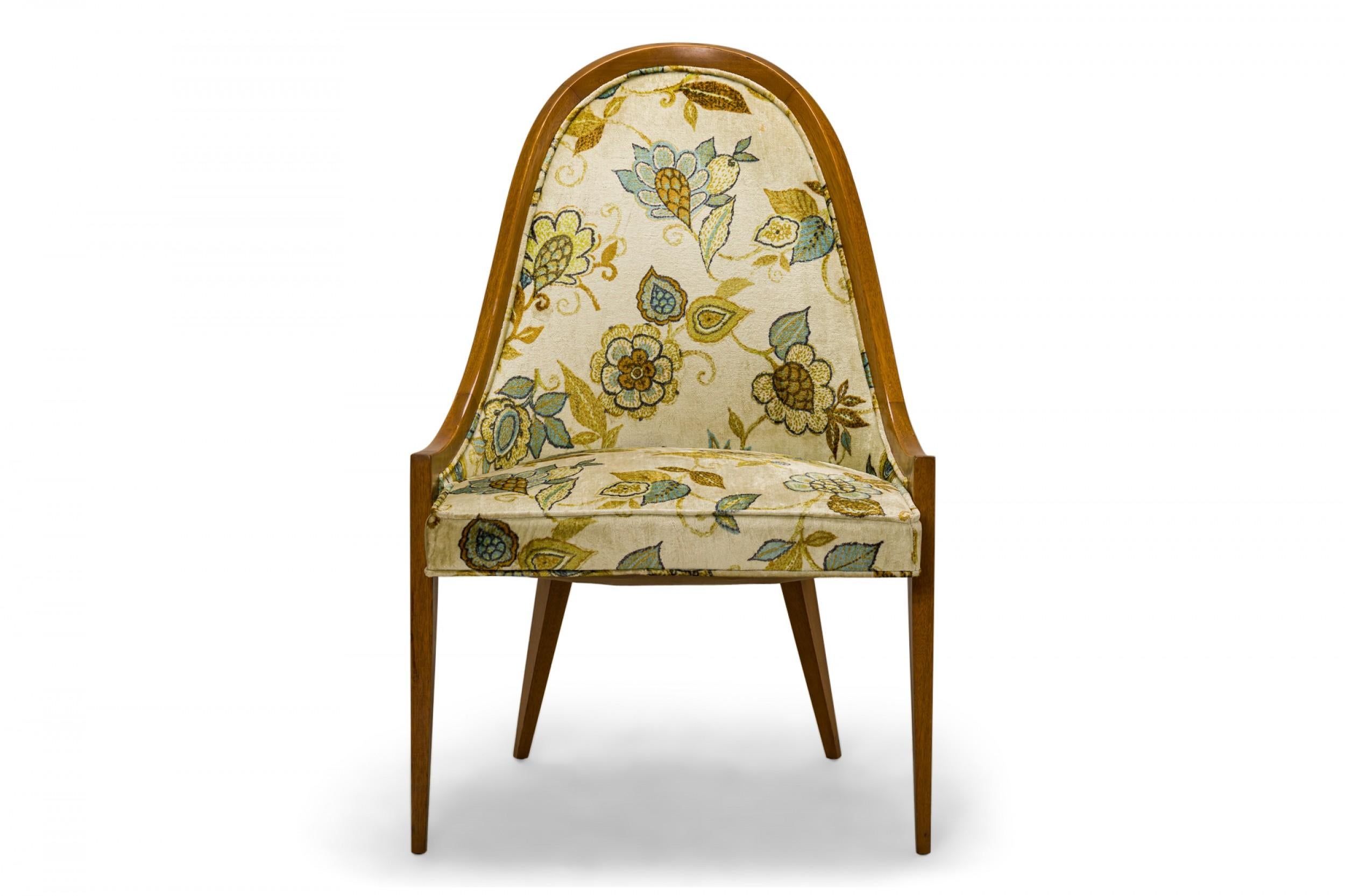 Pair of American mid-century 'Gondola' pull up / side chairs with curved light mahogany frames and beige, brown, green, and blue floral print fabric upholstered seat backs and cushions, resting on four tapered mahogany dowel legs. (HARVEY
